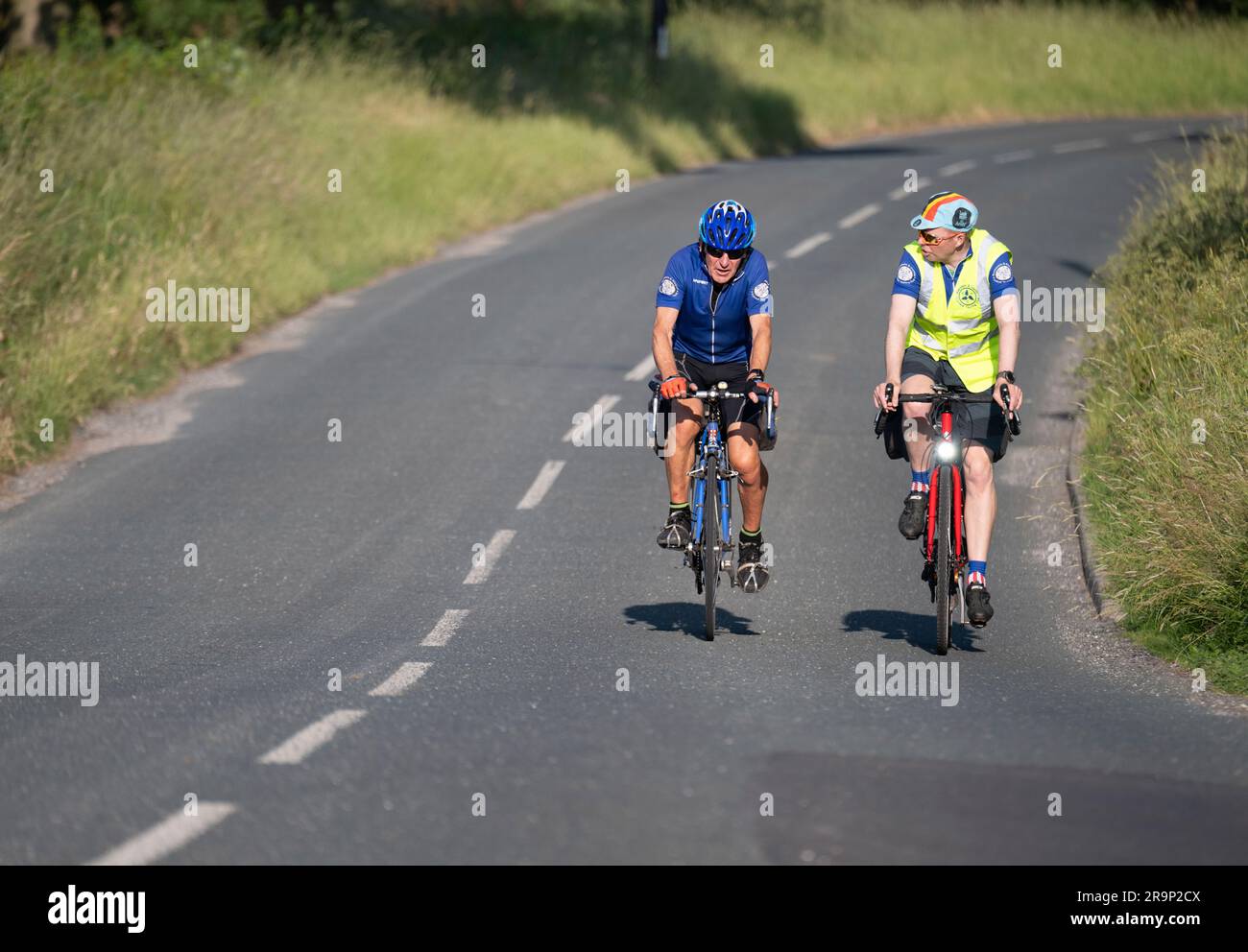 Zwei Fahrradtouristen auf einer abendlichen Fahrt im Sommer in Bashall Eaves, Lancashire, Großbritannien. Stockfoto