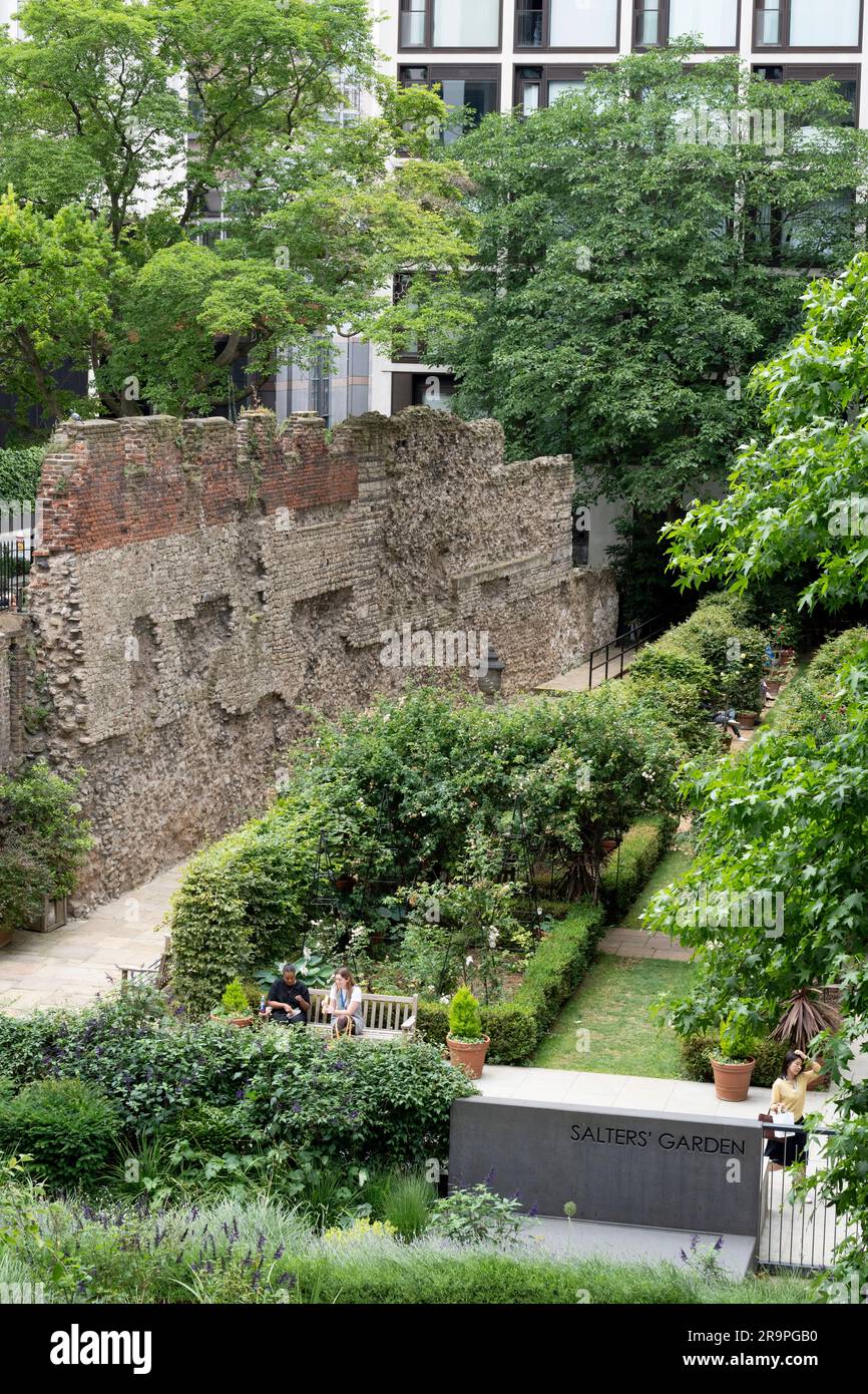 Stadtarbeiter genießen den relativen Frieden der modernen Metropole im Salters' Garden unter den Überresten der alten römischen Mauer, die einst die Grenze der antiken Stadt Londinium bildete - aber jetzt mit der Quadratmeile der Stadt London aus dem 21. Jahrhundert, Das Finanzviertel der Hauptstadt am 27. Juni 2023 in London, England. Die römische Mauer wurde zwischen 190 und 225 als defensive Mauer aus Stein um die Landseite der Stadt errichtet. Die Londoner Mauer war eines der größten Bauprojekte, die in römischem Großbritannien durchgeführt wurden und etwa 85.000 Tonnen Lumpen aus Kentish erforderten Stockfoto