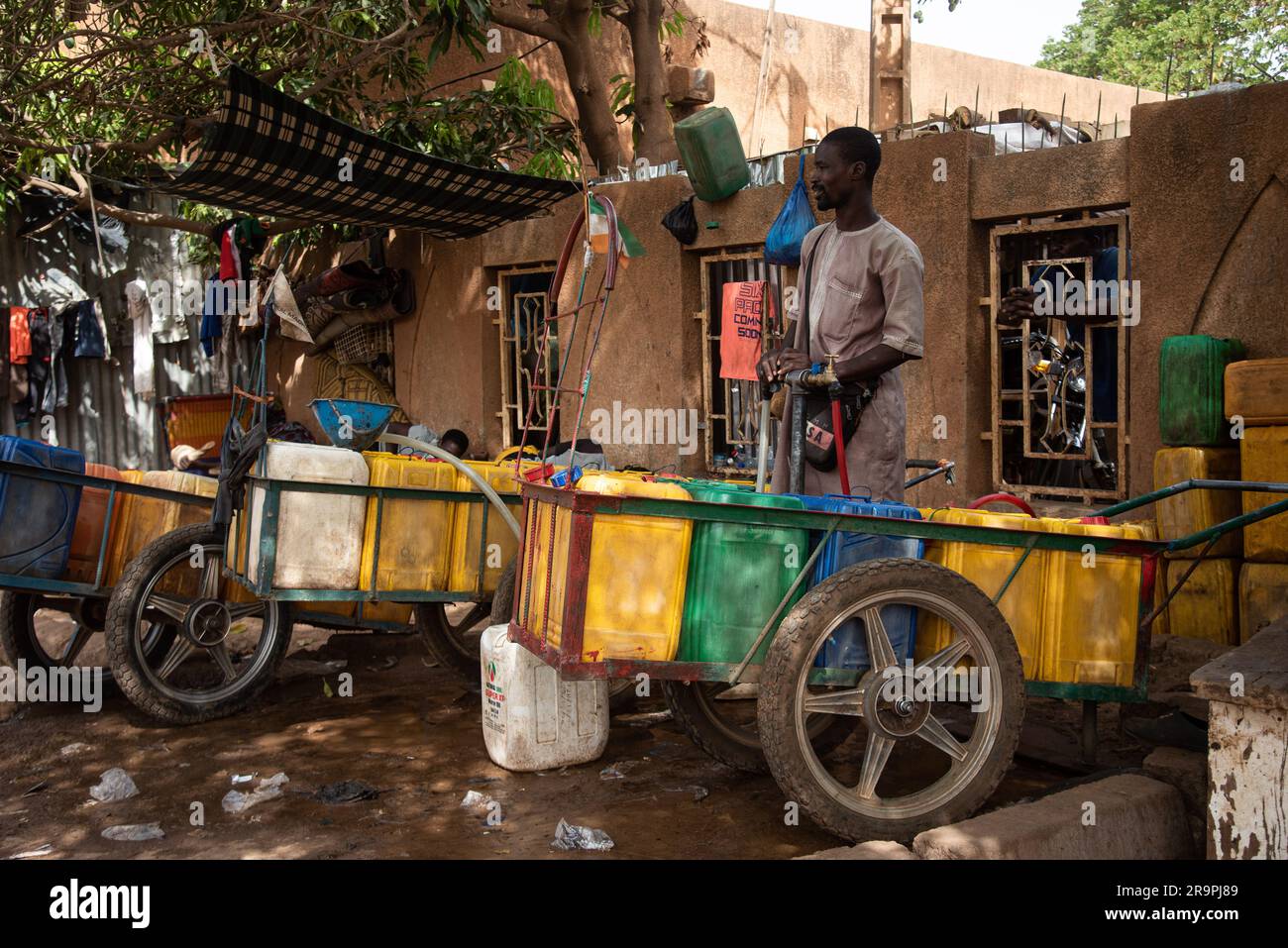 Nicolas Remene / Le Pictorium - Zugang zu Trinkwasser und Standrohren in Niamey, Niger - 28/4/2020 - Niger / Niamey / Niamey - Ein junger Nigerianer überträgt Wasser von einem Kanister in einen anderen, um eine Familie in Niamey zu versorgen, 28. April 2020. In Niamey, Niger, herrscht in der heißen Jahreszeit zwischen Anfang März und Ende Mai in vielen Stadtvierteln mehrmals täglich Wassermangel, und in einigen Randbezirken kann dieser Mangel mehrere Tage andauern. Das macht es für Bewohner sehr schwierig, ihr Getränk zu bekommen Stockfoto