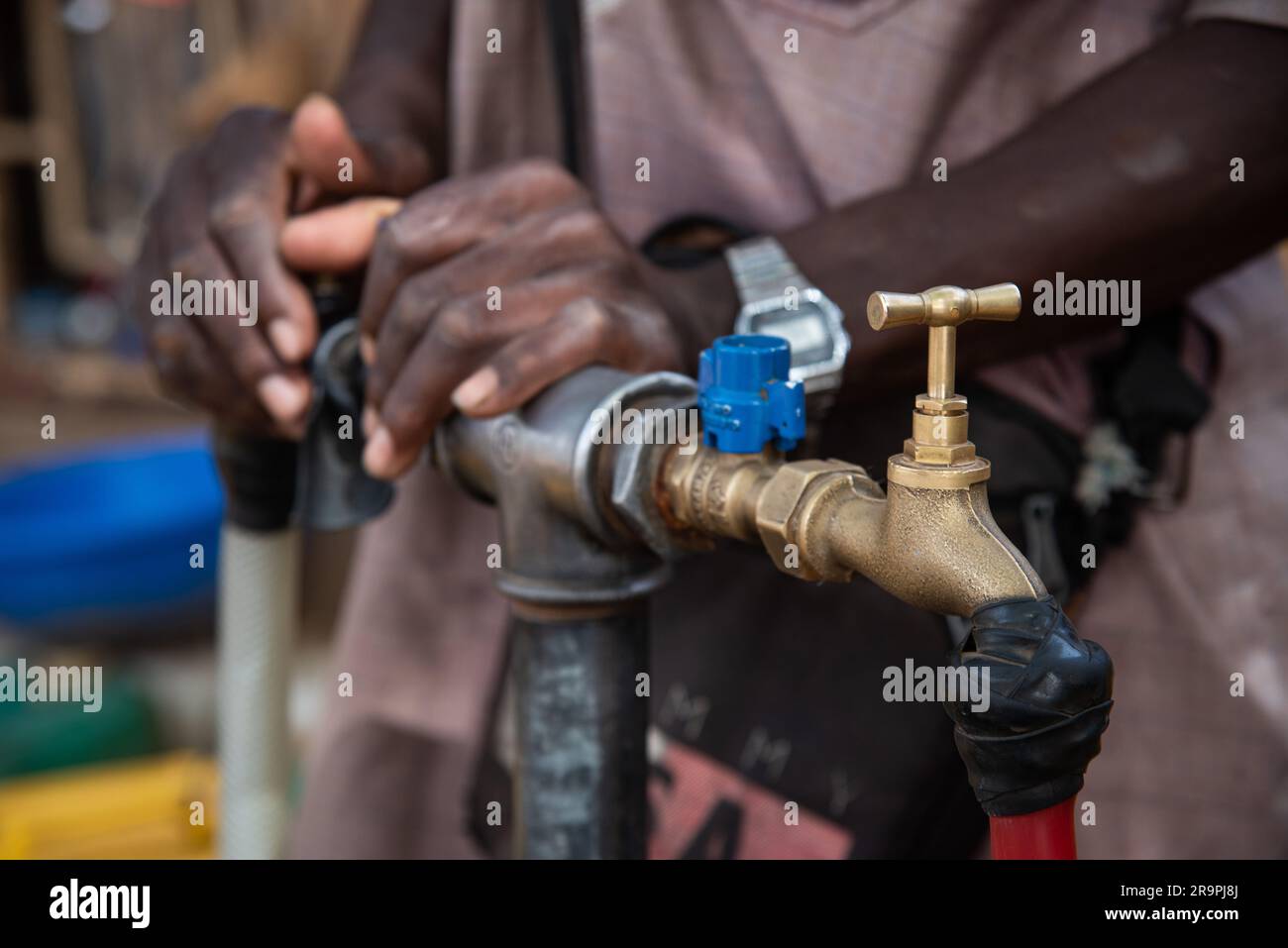 Nicolas Remene/Le Pictorium - Zugang zu Trinkwasser und Standrohren in Niamey, Niger. , . Niger/Niamey/Niamey - Ein junger Nigerianer überträgt Wasser von einem Kanister in einen anderen, um eine Familie in Niamey zu versorgen, 28. April 2020. In Niamey, Niger, herrscht in der heißen Jahreszeit zwischen Anfang März und Ende Mai in vielen Stadtvierteln mehrmals täglich Wassermangel, und in einigen Randbezirken kann dieser Mangel mehrere Tage andauern. Dadurch wird es für die Bewohner sehr schwierig, ihr Getränk zu erhalten Gutschein: LE PICTORIUM/Alamy Live News Stockfoto