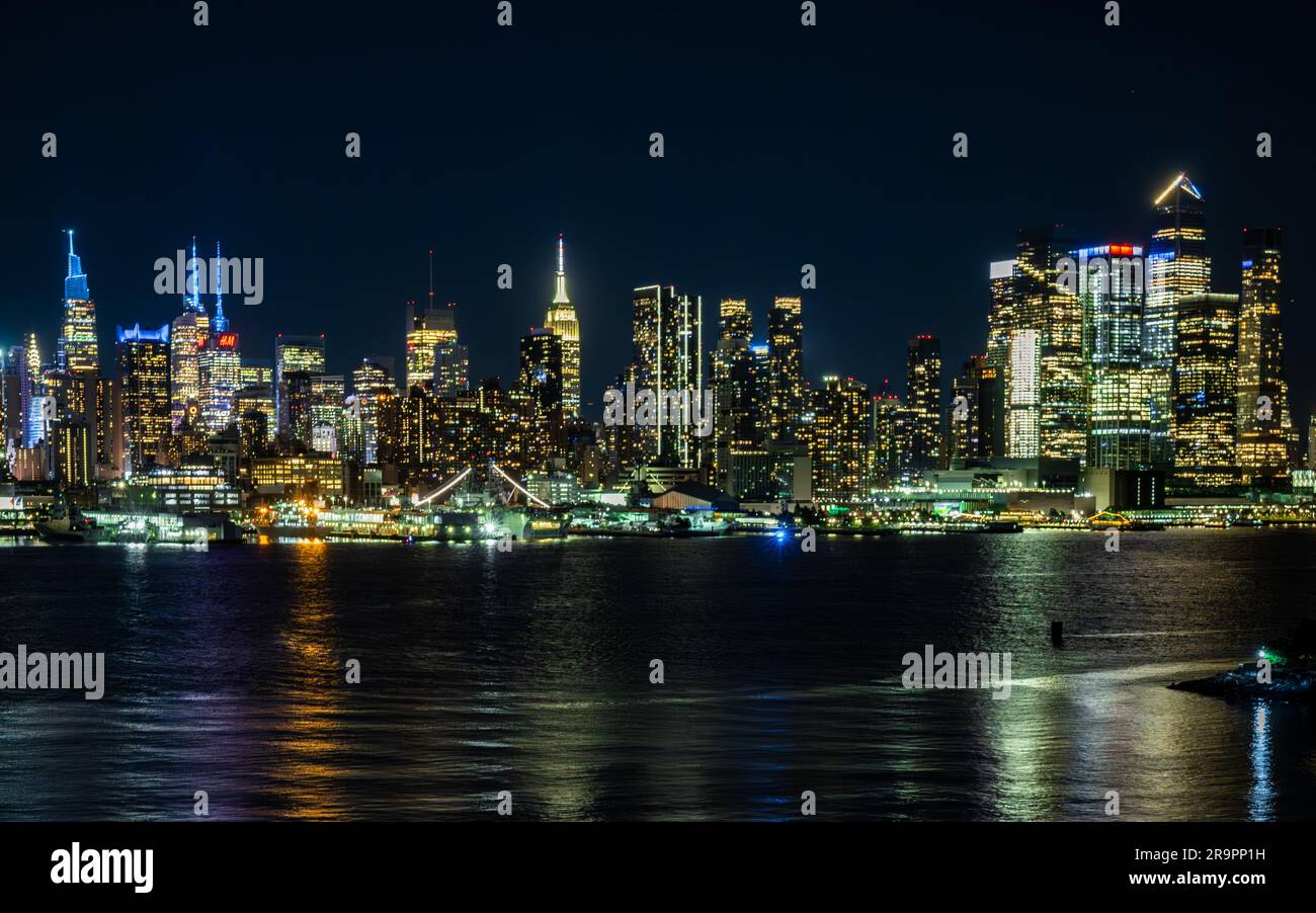 Die atemberaubende nächtliche Skyline von New York City, beleuchtet von lebendigen Lichtern. Stockfoto