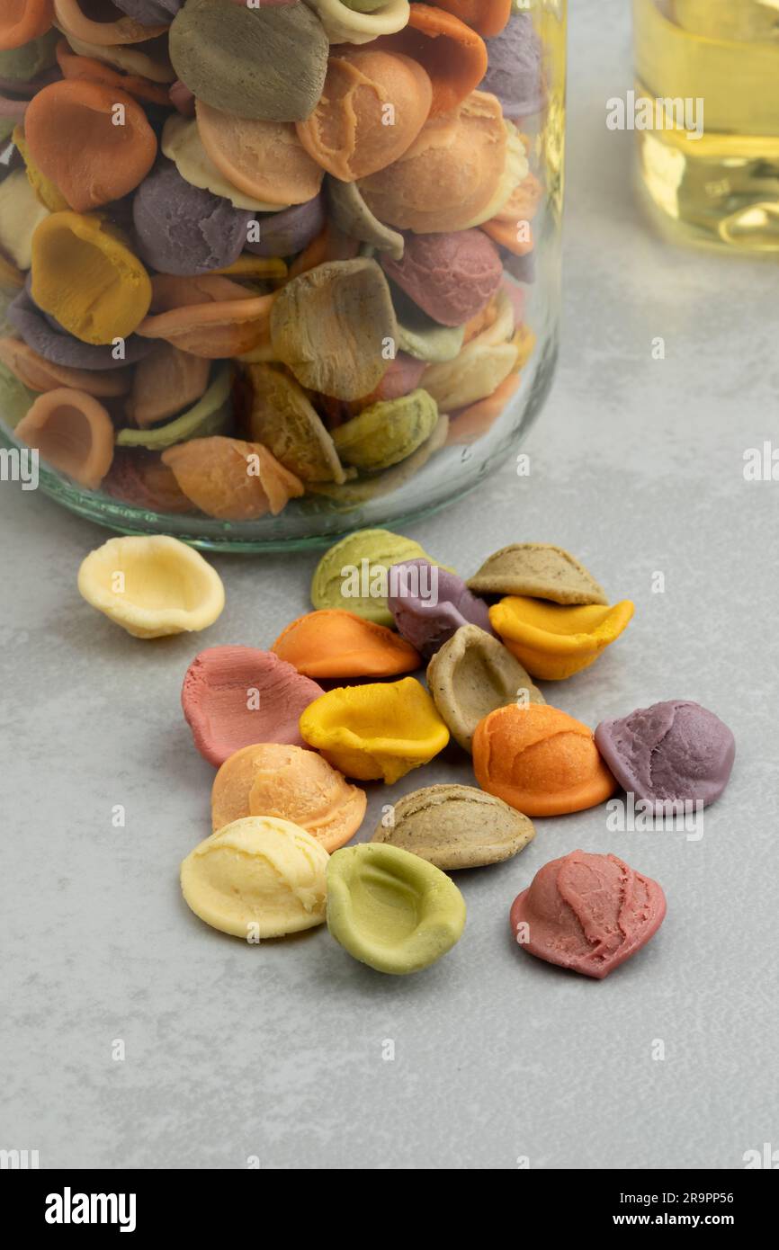 Bunte italienische rohe Orecchiette Arcobaleno Pasta, Regenbogenpasta, in einer Glasschüssel aus nächster Nähe Stockfoto
