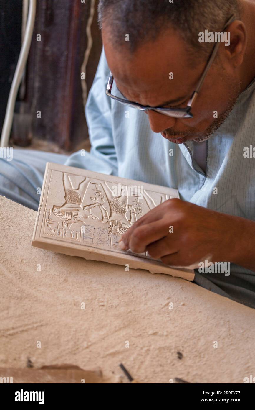 Einheimischer Handwerker, der moderne Souvenirreproduktionen von Basreliefschnitzereien aus dem Leichentempel der Hatschepsut in Deir al-Bahri, Luxor, herstellt Stockfoto