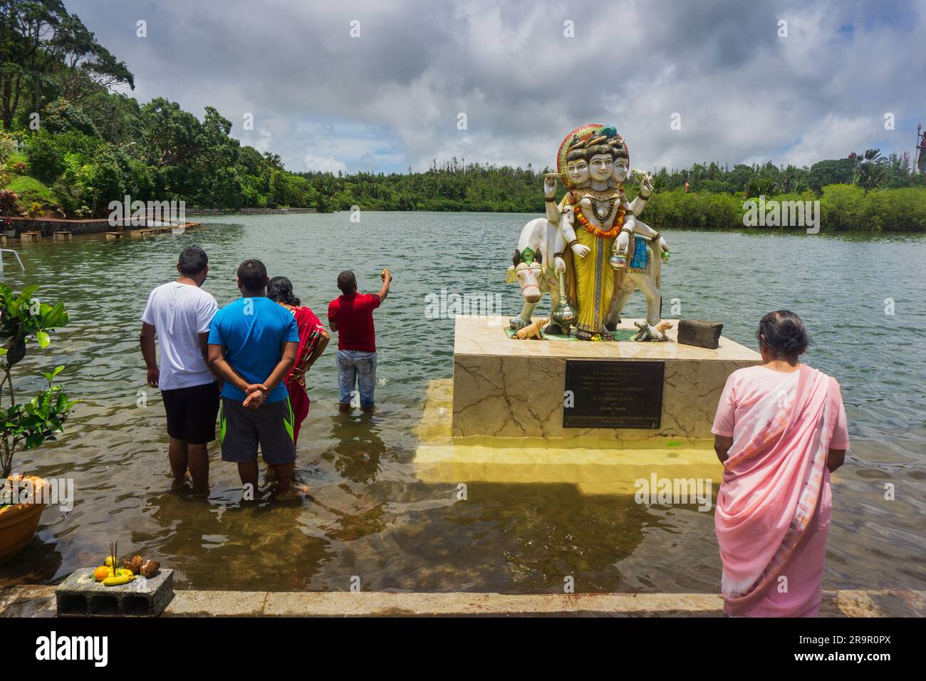 Frau in Sari und andere Hindu-Anhänger, die die göttliche Statue am heiligen See von Grand Bassin anbeten, auch bekannt als Ganga Talao auf Mauritius Stockfoto