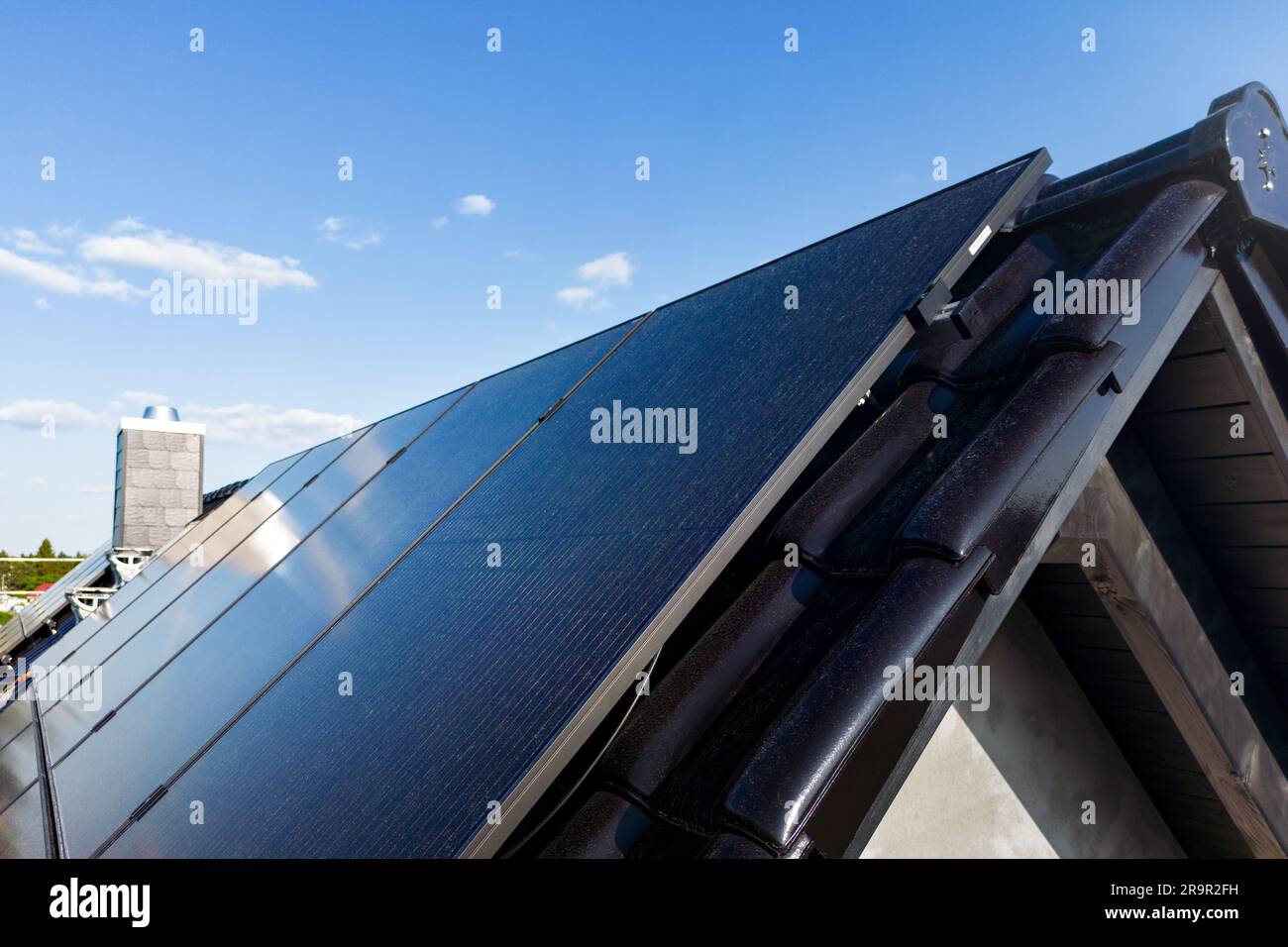 Moderne Sonnenkollektoren auf einem Giebeldach Stockfoto