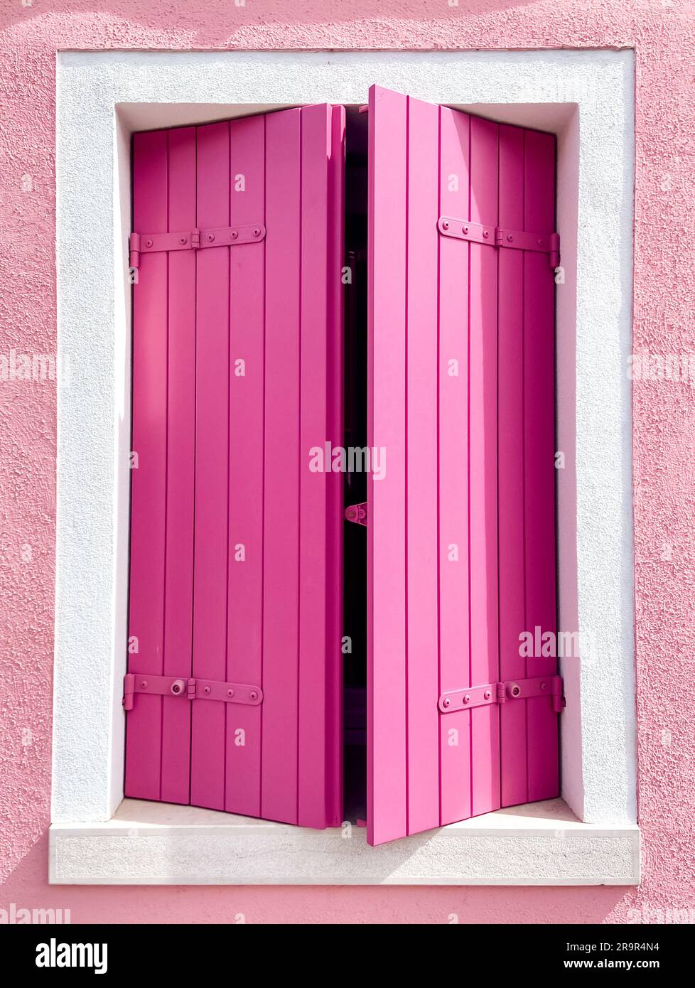 Kontrastreiche, hellrosa Fenster in burano Stockfoto