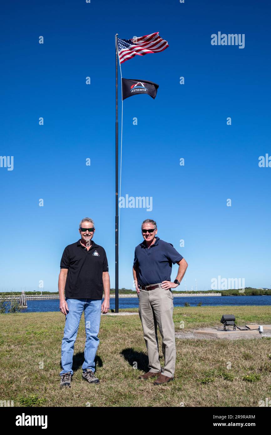 Entfernung der Artemis-Flagge an der LC 39 Pressestelle. Die Artemis-Flagge wird am 6. Januar 2023 im Anschluss an die erfolgreiche Artemis I-Mission vom NASA News Center im Kennedy Space Center der Agentur in Florida entfernt. Auf der linken Seite befindet sich Phil Weber, Senior Technical Integration Manager bei Exploration Ground Systems (EGS), zusammen mit dem ehemaligen EGS Manager Mike Bolger. Beide Männer waren während der Artemis I in ihren jeweiligen Rollen tätig und gingen Ende 2022 in den Ruhestand. Das Space Launch System (SLS) der NASA und das Orion-Raumschiff starteten am 16. November 2022 vom Kennedy Launch Complex 39B. Orion ist im Pazifik gespritzt Stockfoto