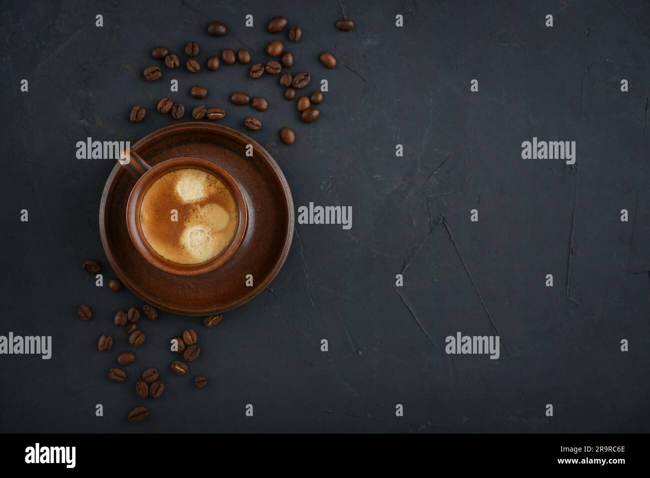 Tasse Kaffee mit Kaffeebohnen auf schwarzem Hintergrund, Draufsicht Stockfoto
