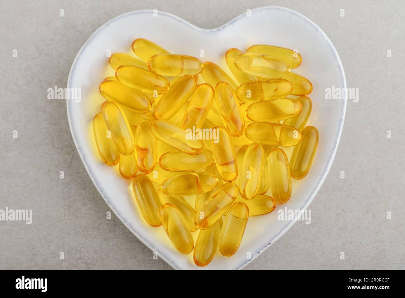 Draufsicht der Omega-3 Fischölkapseln auf einer Platte auf einem Betontisch Stockfoto
