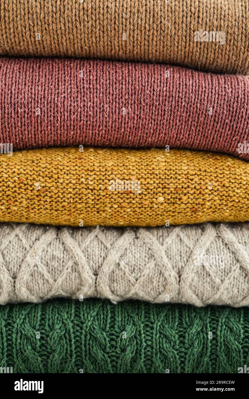 Ein Haufen handgestrickter Winterkleidung als Hintergrund: Pullover, Strickwaren Stockfoto