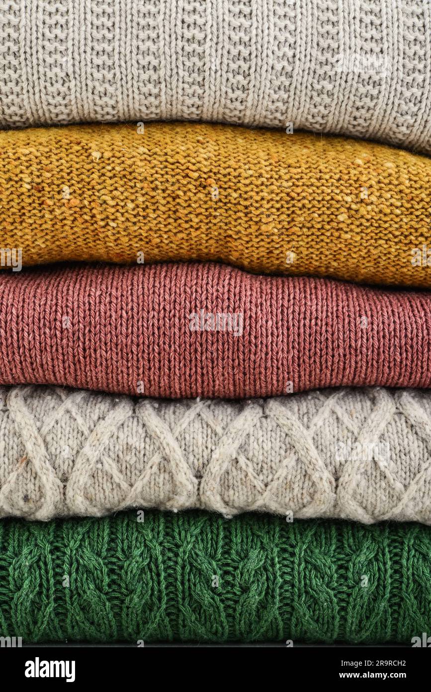 Ein Haufen handgestrickter Winterkleidung als Hintergrund: Pullover, Strickwaren Stockfoto