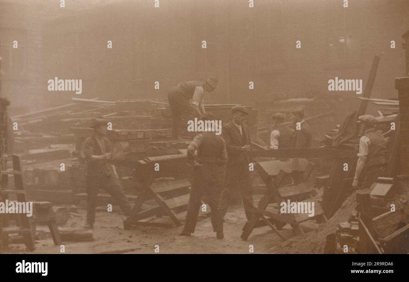 Bolton-Bauernhof oder Freimaurerhof, fotografiert im frühen 20. Jahrhundert. Das Bild zeigt zwei Sätze von Männern, die zum Schneiden großer Holz- oder Steinblöcke mit einer Kreuzkreissäge arbeiten. Im Hof befinden sich Stapel mit Baumaterial. Das Foto wurde von W. Gredy, 168, St. George's Road, Bolton. Stockfoto
