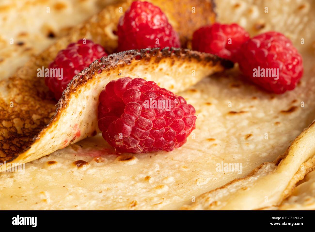Dünne Pfannkuchen mit Himbeeren aus der Nähe, Dessert und Frühstück Stockfoto