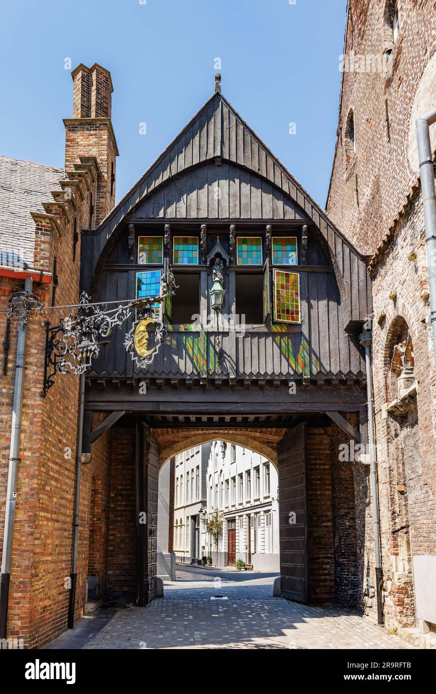 Tür in Form einer schwarzen Holzkapelle mit einem goldenen Halbmondsymbol im Stadtzentrum von Brügge, Belgien Stockfoto