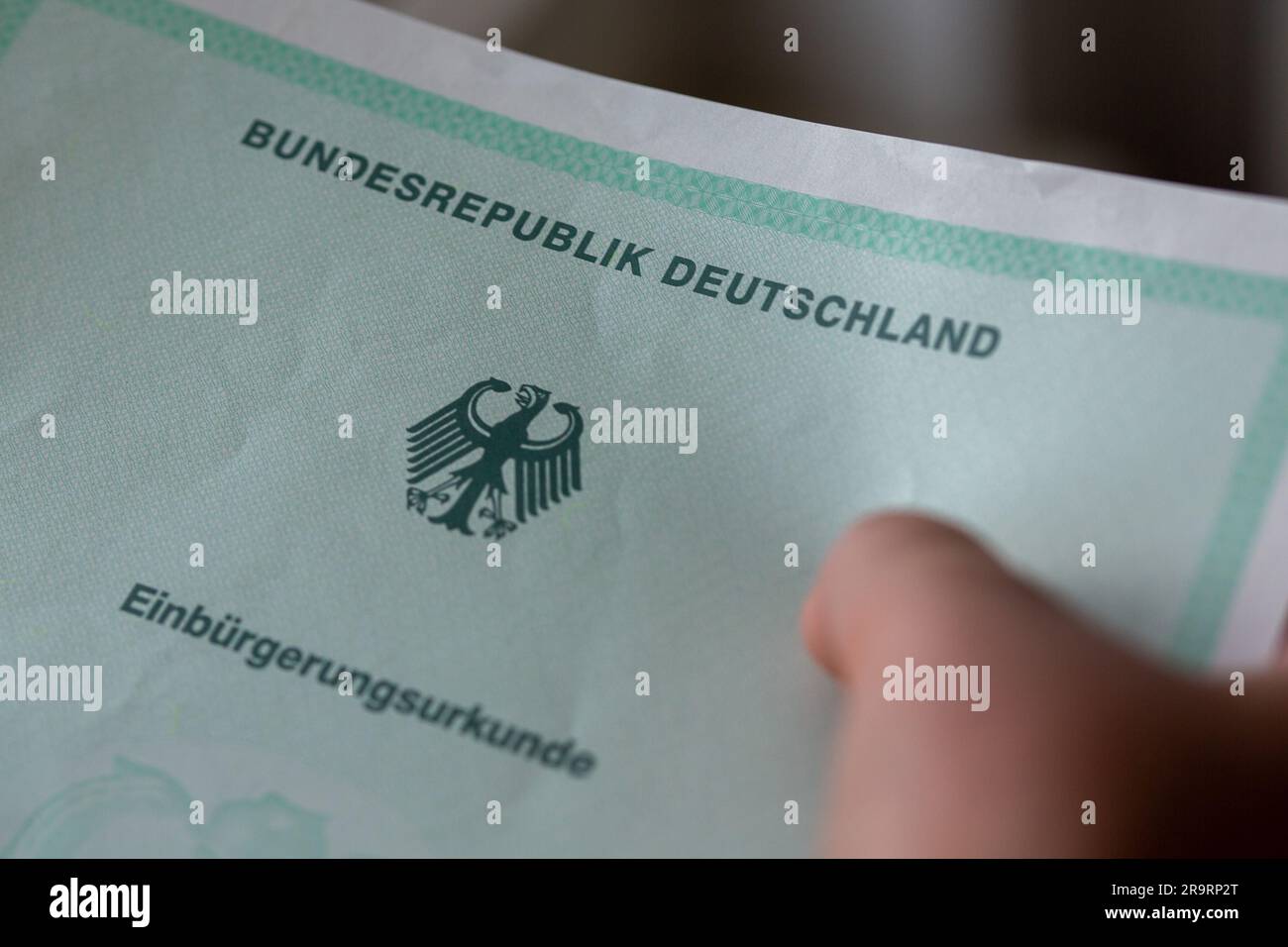 Berlin, Deutschland. 22. Mai 2023. Eine Person verfügt über eine Einbürgerungsbescheinigung der Bundesrepublik Deutschland. Ausländer in Deutschland werden demnächst die deutsche Staatsbürgerschaft leichter erlangen können, so die Pläne der Bundesregierung. Kredit: Fernando Gutierrez-Juarez/dpa/Alamy Live News Stockfoto