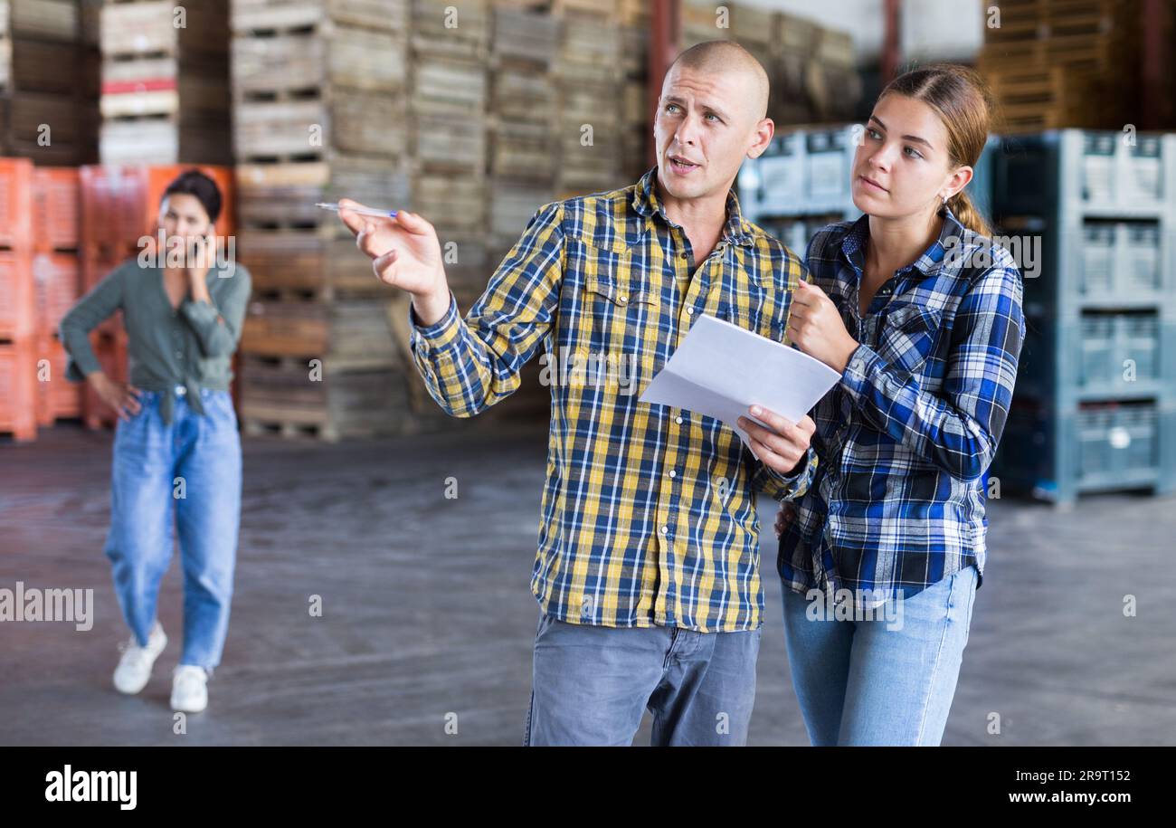 Mann, der sich im Lager mit einer jungen Frau unterhalten hat Stockfoto