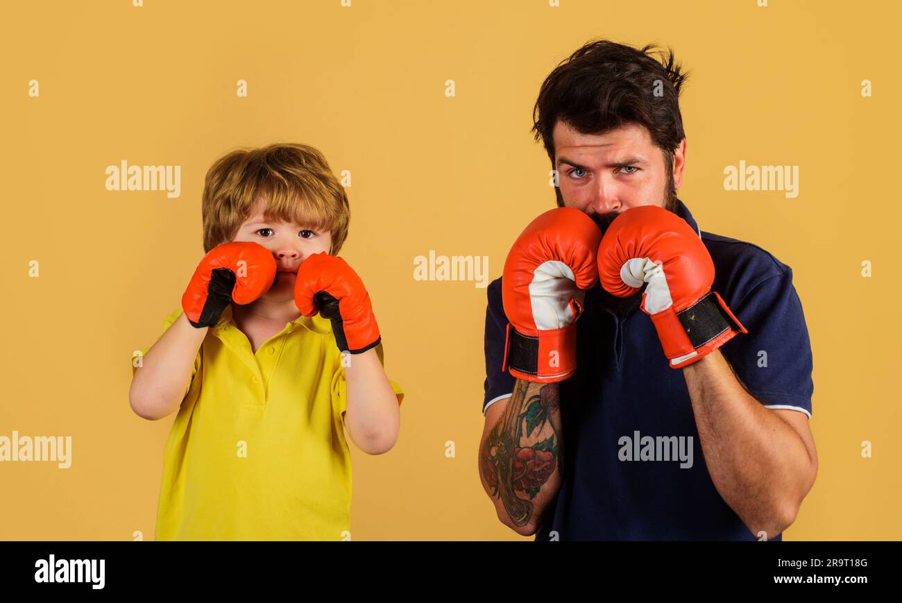 Kleiner Boxer mit Trainer beim Boxtraining. Junge und Trainer in Boxhandschuhen. Ein Junge mit Boxtrainer, bereit zum Sparring. Kind und Trainer rein Stockfoto