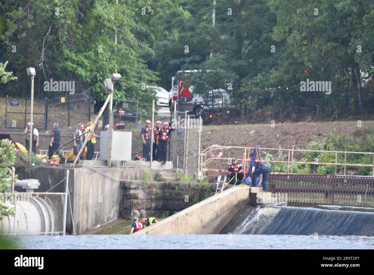 Clifton, Usa. 28. Juni 2023. Ersthelfer wurden während einer aktiven Rettung auf der Clifton-Seite des Passaic River in Passaic aus dem Wasser gehoben. Zeugen sagen, dass Bauunternehmer draußen auf dem Fluss waren, um etwas zu arbeiten, als eines der Boote über die Wasserfälle fiel und eine Person herausfiel. Als die Feuerwehr versuchte, den Bauunternehmer zu retten, kippte ein Feuerboot im Fluss um. Zwei Ersthelfer eines im Wasser gestrandeten Bootes wurden gerettet. Kredit: SOPA Images Limited/Alamy Live News Stockfoto