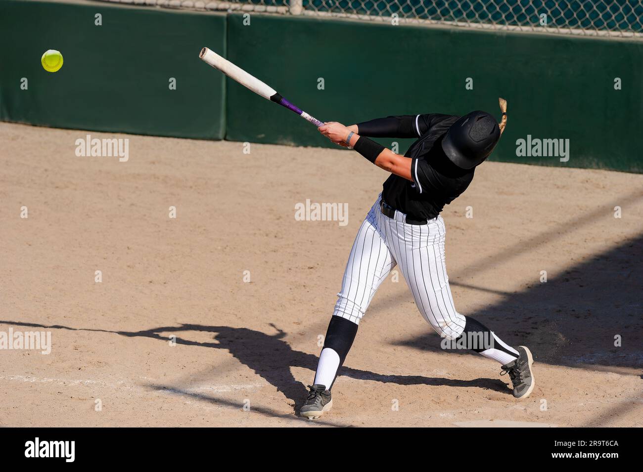 Ein Baseball-Softball-Spieler schlägt den Schläger und schlägt den Ball Stockfoto