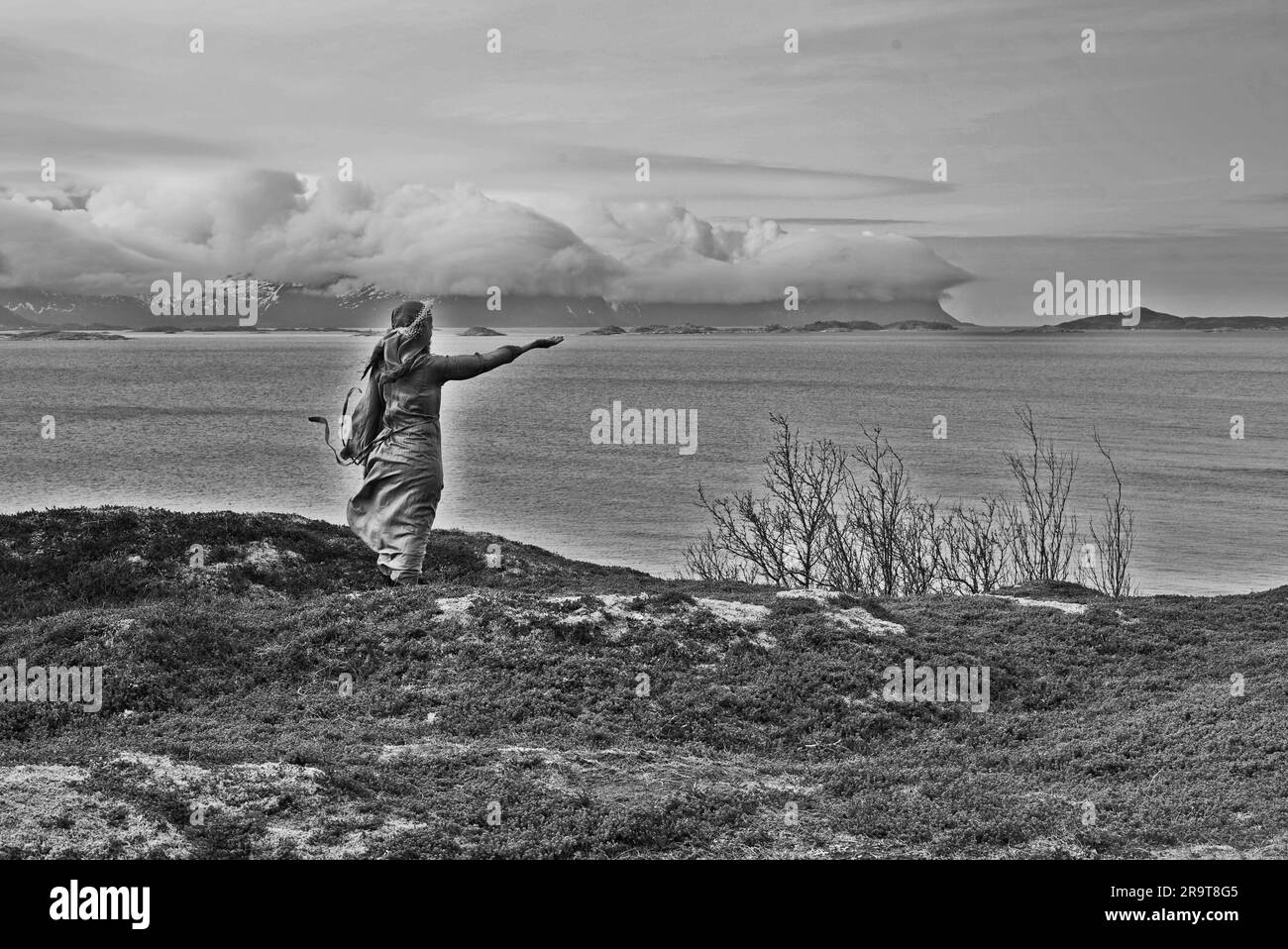 Eine nordische heidnische Frau, die dem Meer ein Opfer bringt. Stockfoto