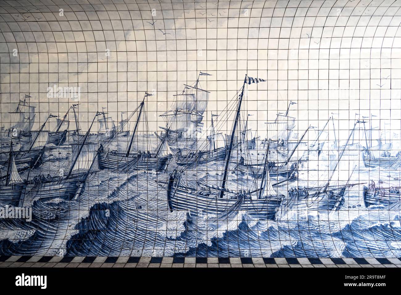 Blaue und weiße Fliesen mit einer Meereslandschaft aus hölzernen Segelschiffen auf See, die sich in einem Tunnel in der Nähe des Hauptbahnhofs in Amster befinden Stockfoto
