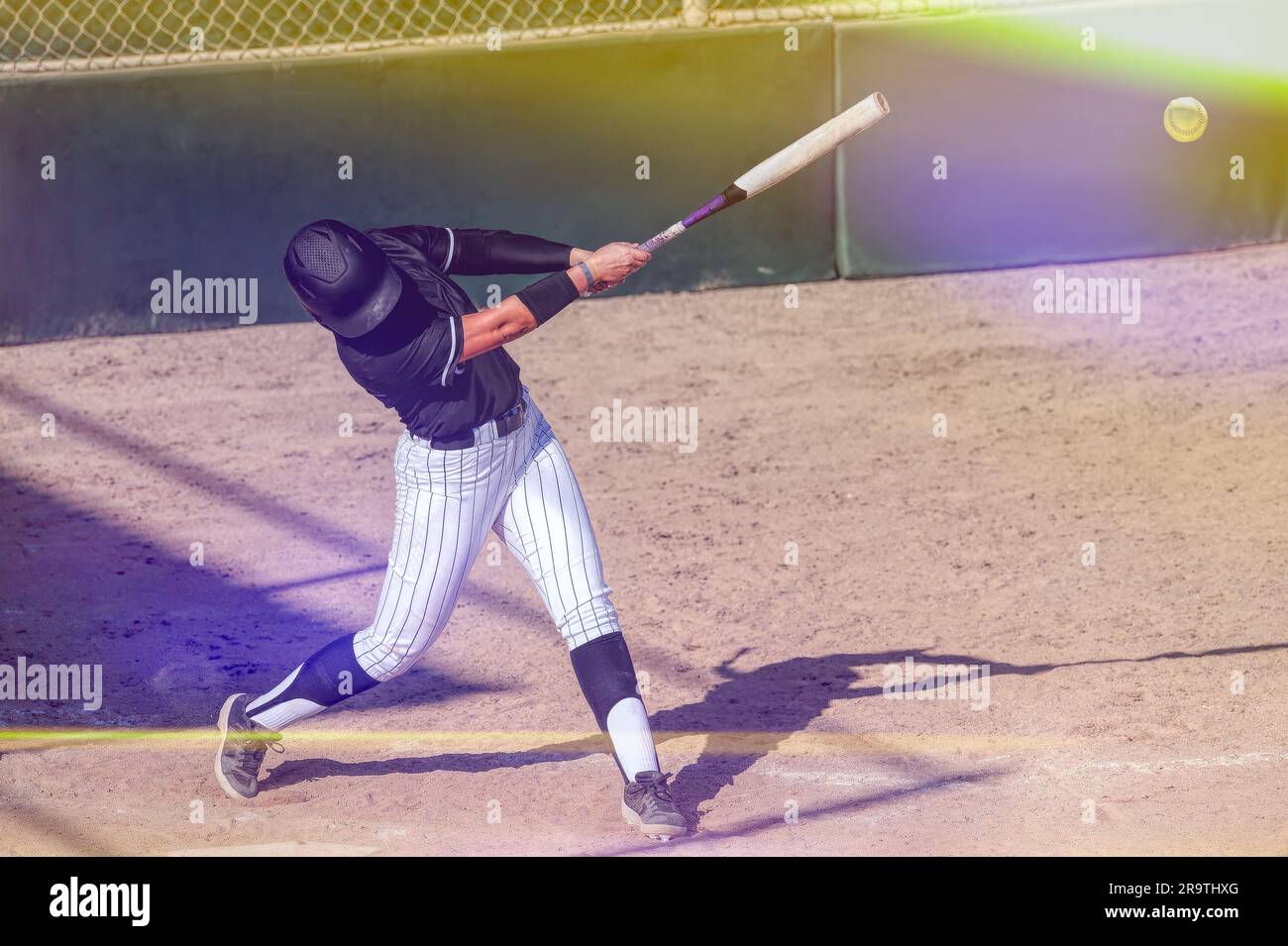 Ein Baseball-Softball-Spieler schlägt den Schläger und schlägt den Ball Stockfoto