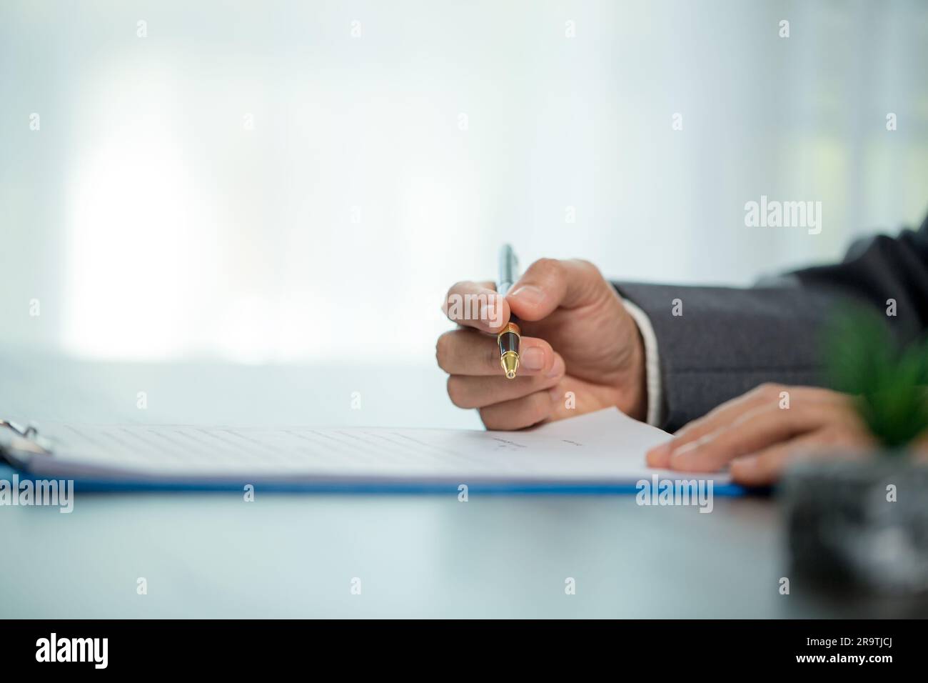 Person für Nahaufnahmen am Arbeitsplatz, professionelle Geschäftsfrau, die am Schreibtisch sitzt, hält eine Unterschrift oder Unterschriftenunterschrift. Angestelltenfrau, die den Vertrag unterzeichnet Stockfoto