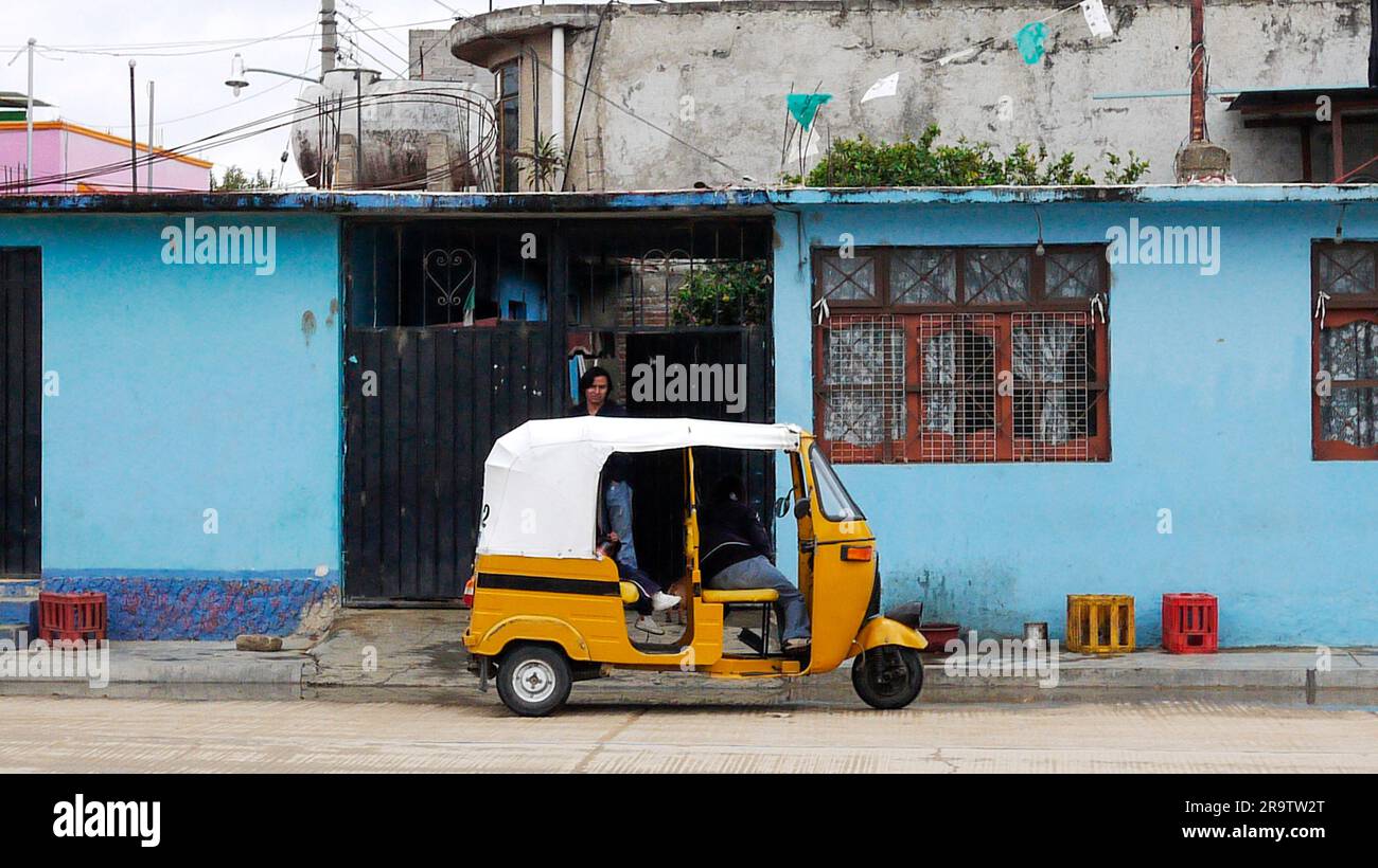 Jinrikisha Taxi parkt am blauen Gebäude, Oaxaca, Mexiko Stockfoto