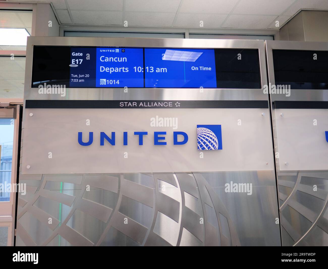 Informationsmonitor an Gate E17, Terminal E, am George Bush International Airport in Houston, Texas mit Abfluginformationen für Cancun, Mexiko. Stockfoto