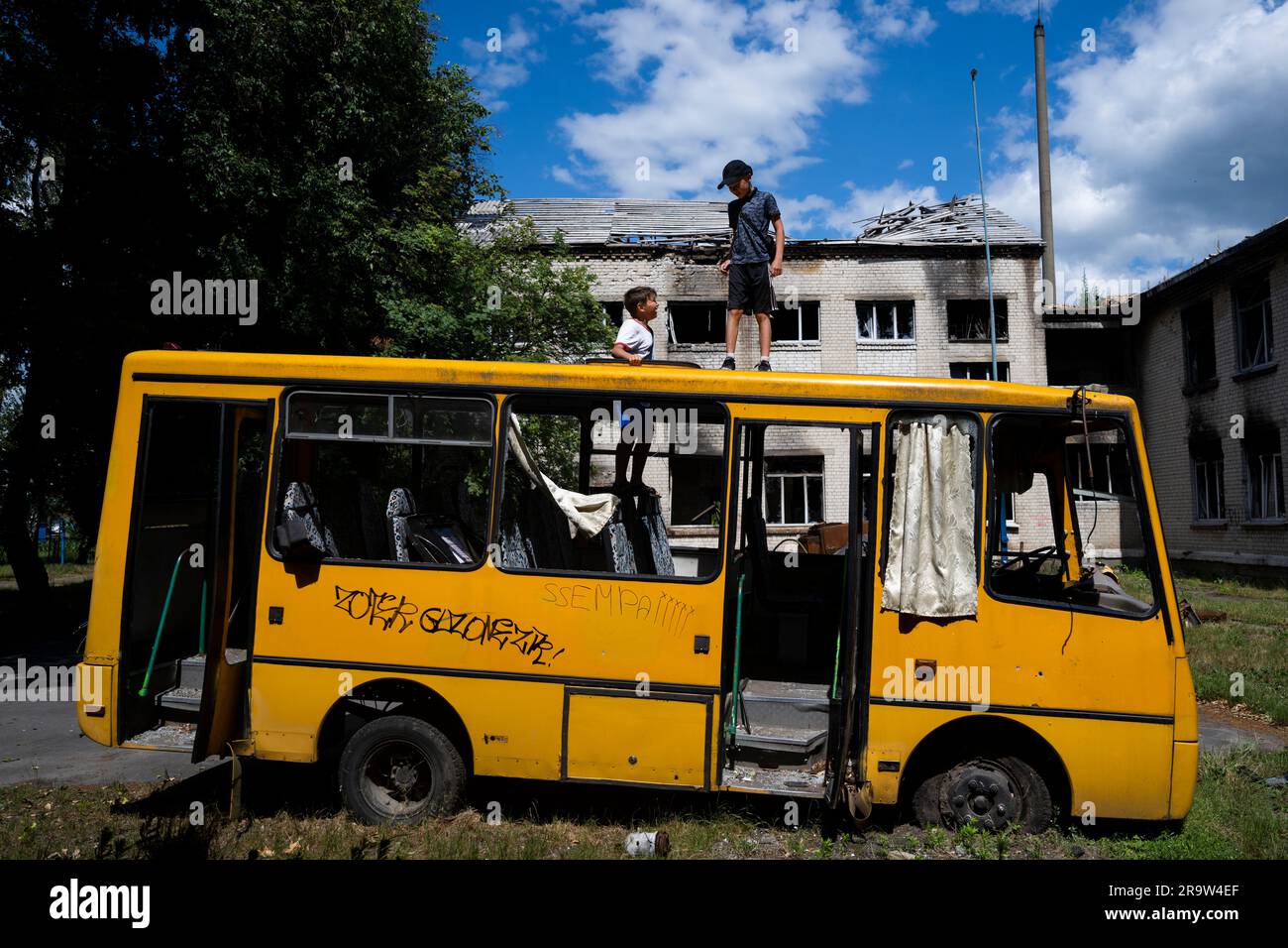 Oblast Kyjevska, Ukraine. 28. Juni 2023. Jungs kriechen am 28. Juni 2023 durch einen zerstörten Bus in Kiew, Ukraine. Kredit: Ondrej Deml/CTK Photo/Alamy Live News Stockfoto