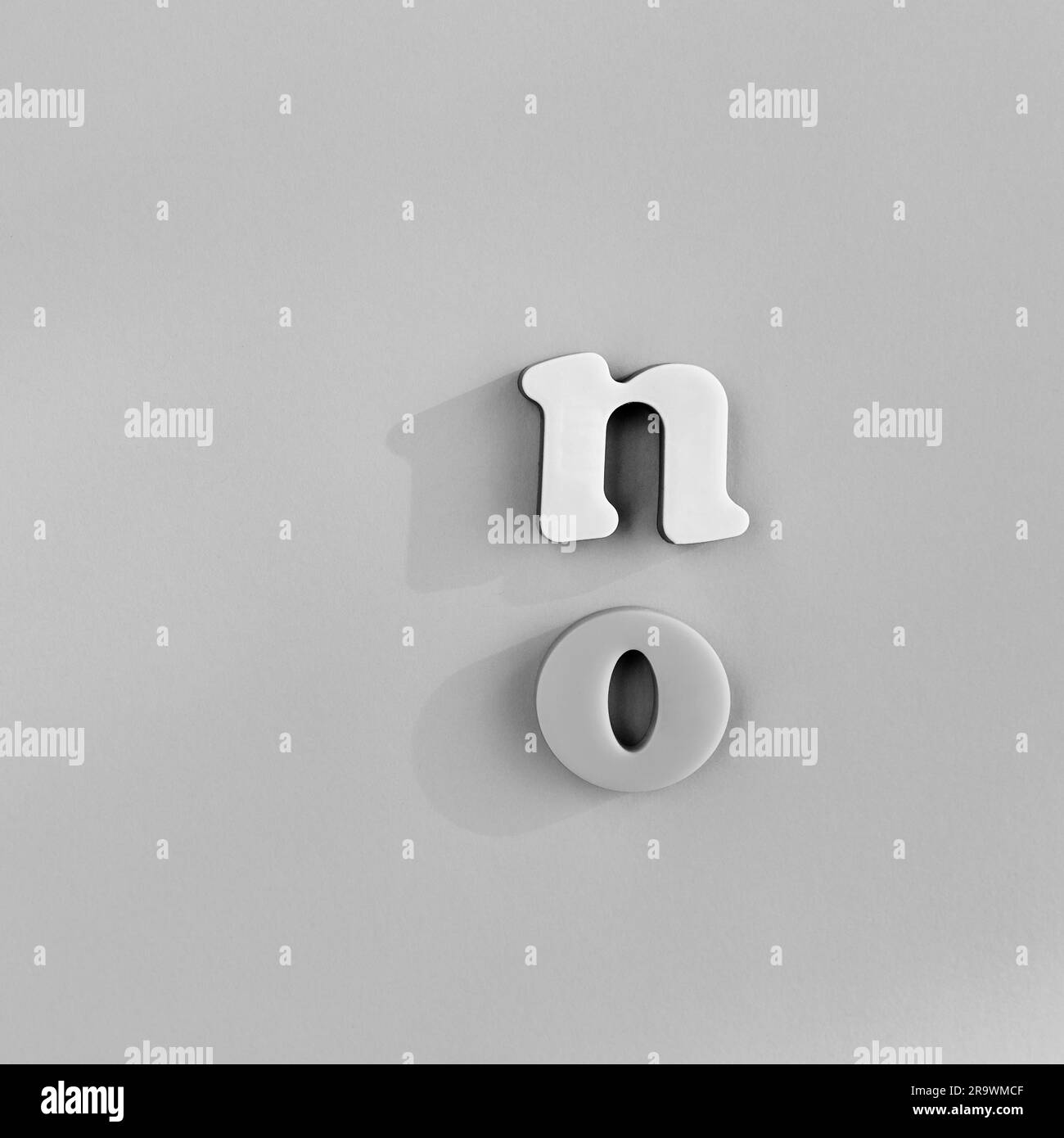 Buchstaben bilden das Wort "Nein", "vertikale Anordnung", "Tischplatte", "Schwarzweiß", "minimalistisch", Symbolbild Stockfoto