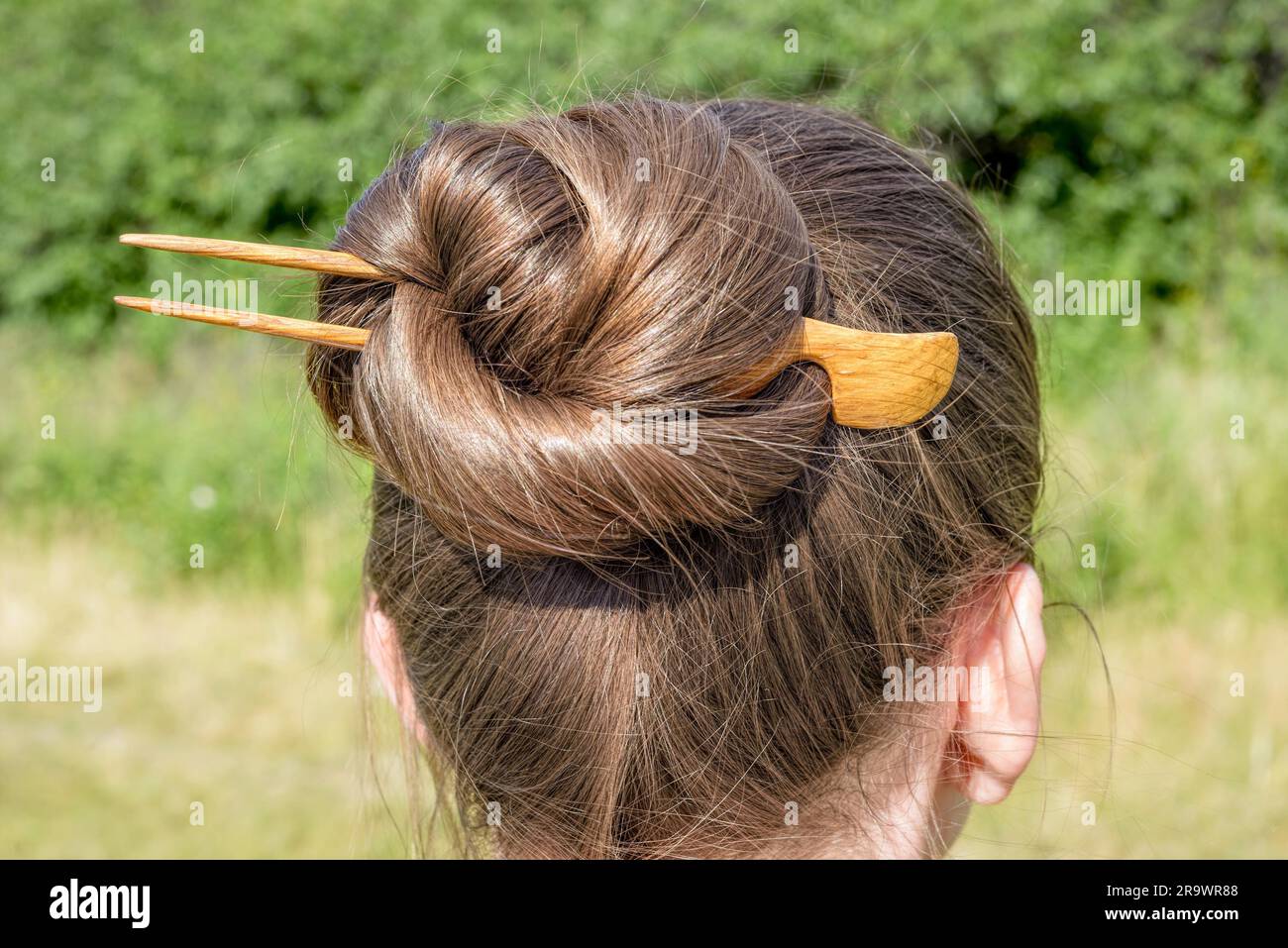 Detail von einem Chignon mit einer hölzernen Haarnadel, das Haar befestigt zusammen zu halten Stockfoto