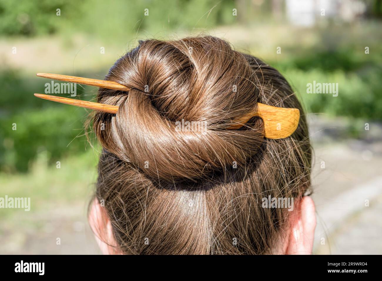 Detail von einem Chignon mit einer hölzernen Haarnadel, das Haar befestigt zusammen zu halten Stockfoto