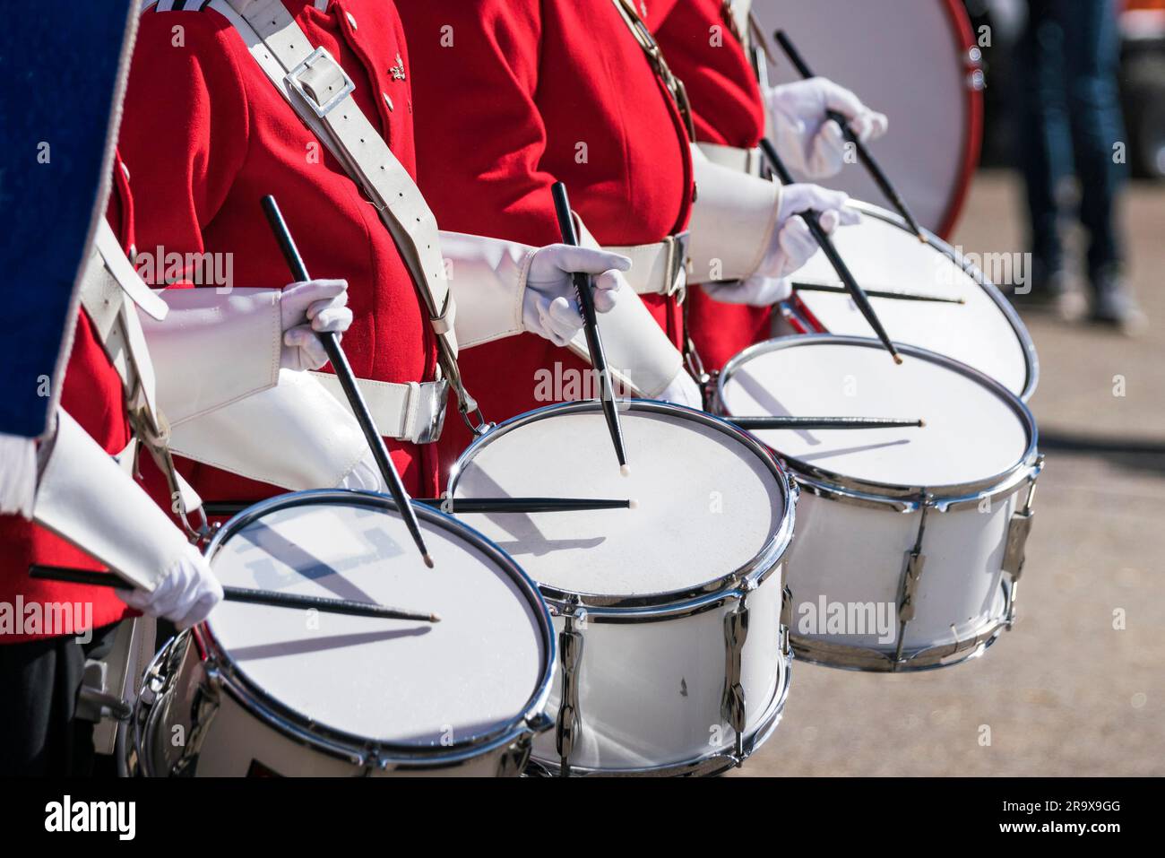 Trommler in roten Uniformen in einer Zeile bei einer Frühling-Parade mit weißen Handschuhen Trommeln am Schlagzeug Stockfoto