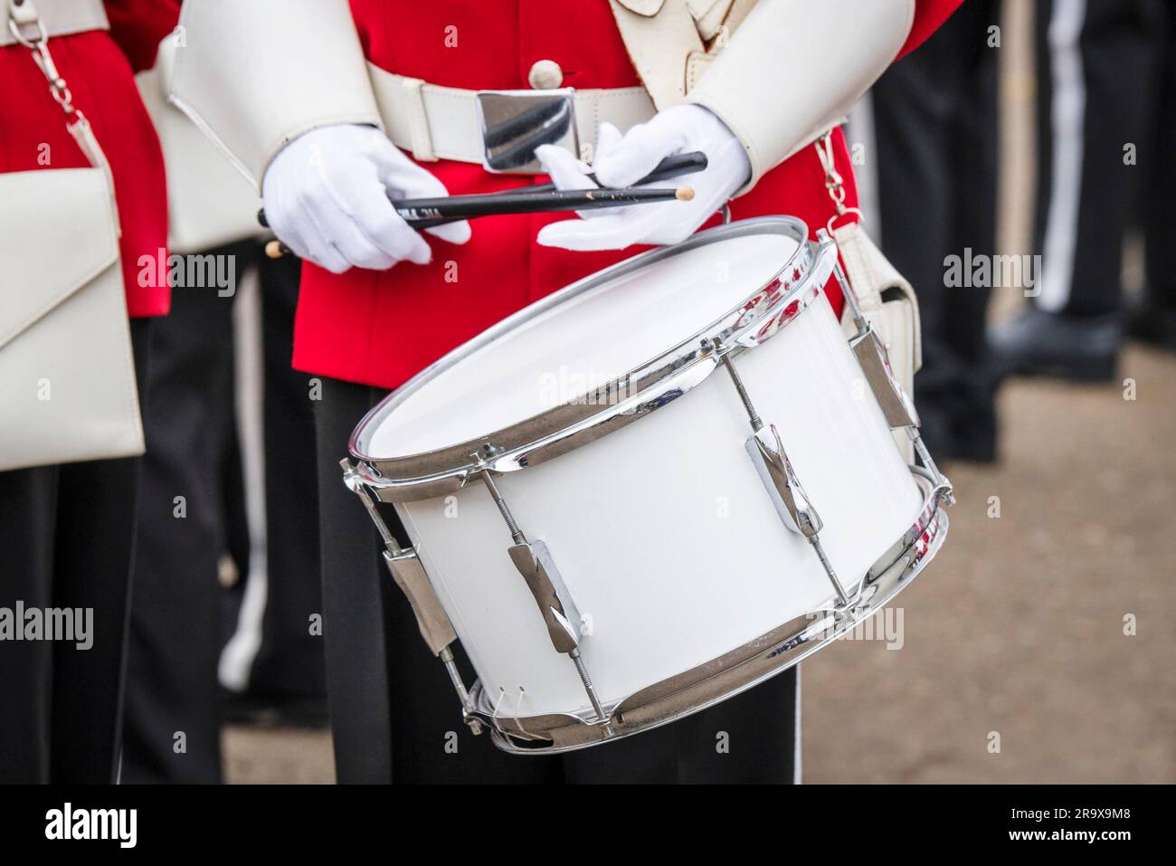 Soldat Schlagzeuger in roter Uniform und weiße Handschuhe gespielt in einem März Stockfoto