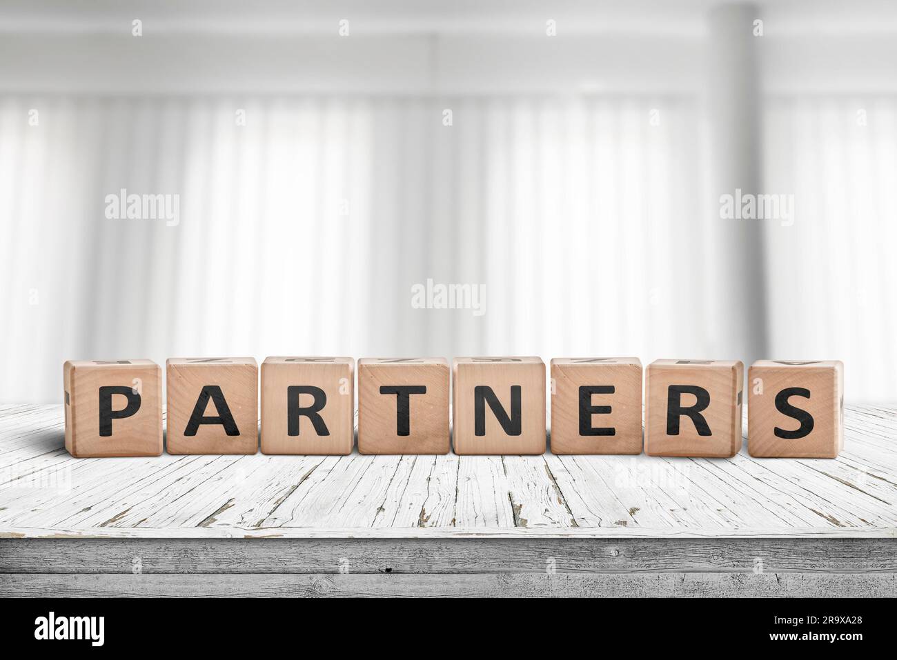 Partner Anmeldung auf einem Schreibtisch in einem hellen Büro mit weißen Vorhängen im Hintergrund Stockfoto