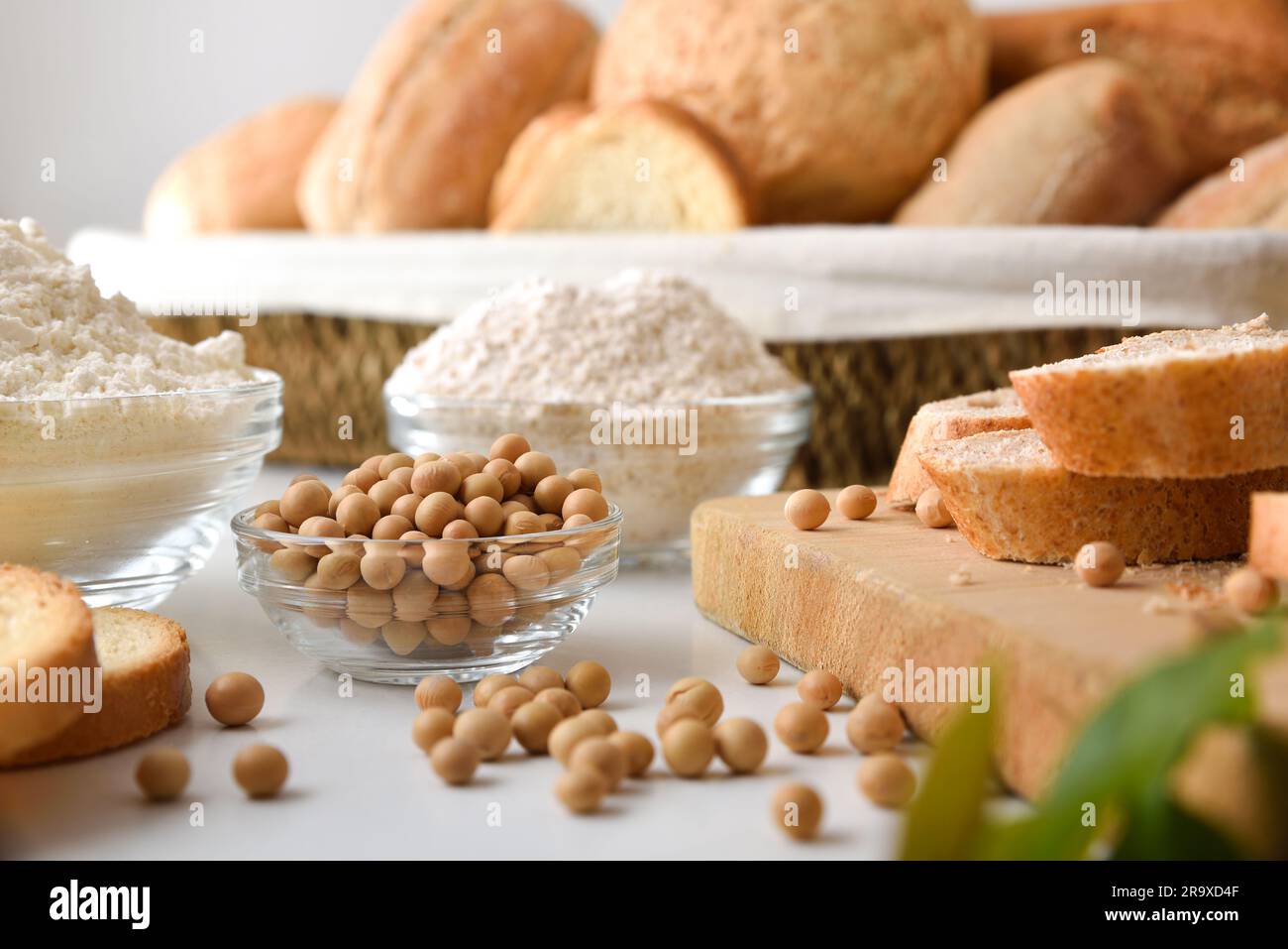 Sojabohnen in einer Glasschüssel mit Soja-Backwaren wie Brot und Mehl. Vorderansicht. Stockfoto
