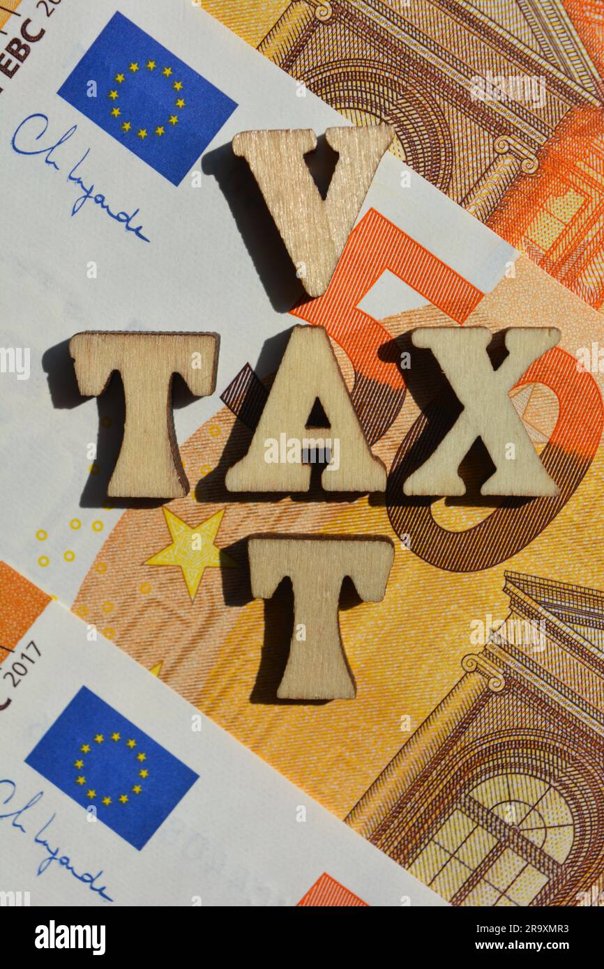 Mehrwertsteuer, Steuern, Wörter in hölzernen Buchstaben in Kreuzworträtselform, isoliert auf dem Hintergrund von fünfzig Euro-Banknoten Stockfoto