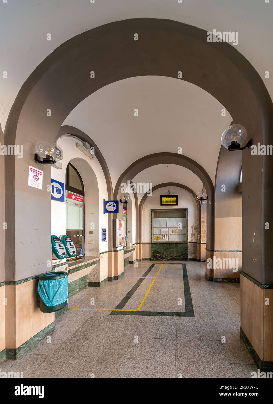 Savigliano, Cuneo, Italien - 20. März 2023: Fahrkartenschalter mit Bogenarchitektur und Zugfahrplan im Bahnhof Stockfoto