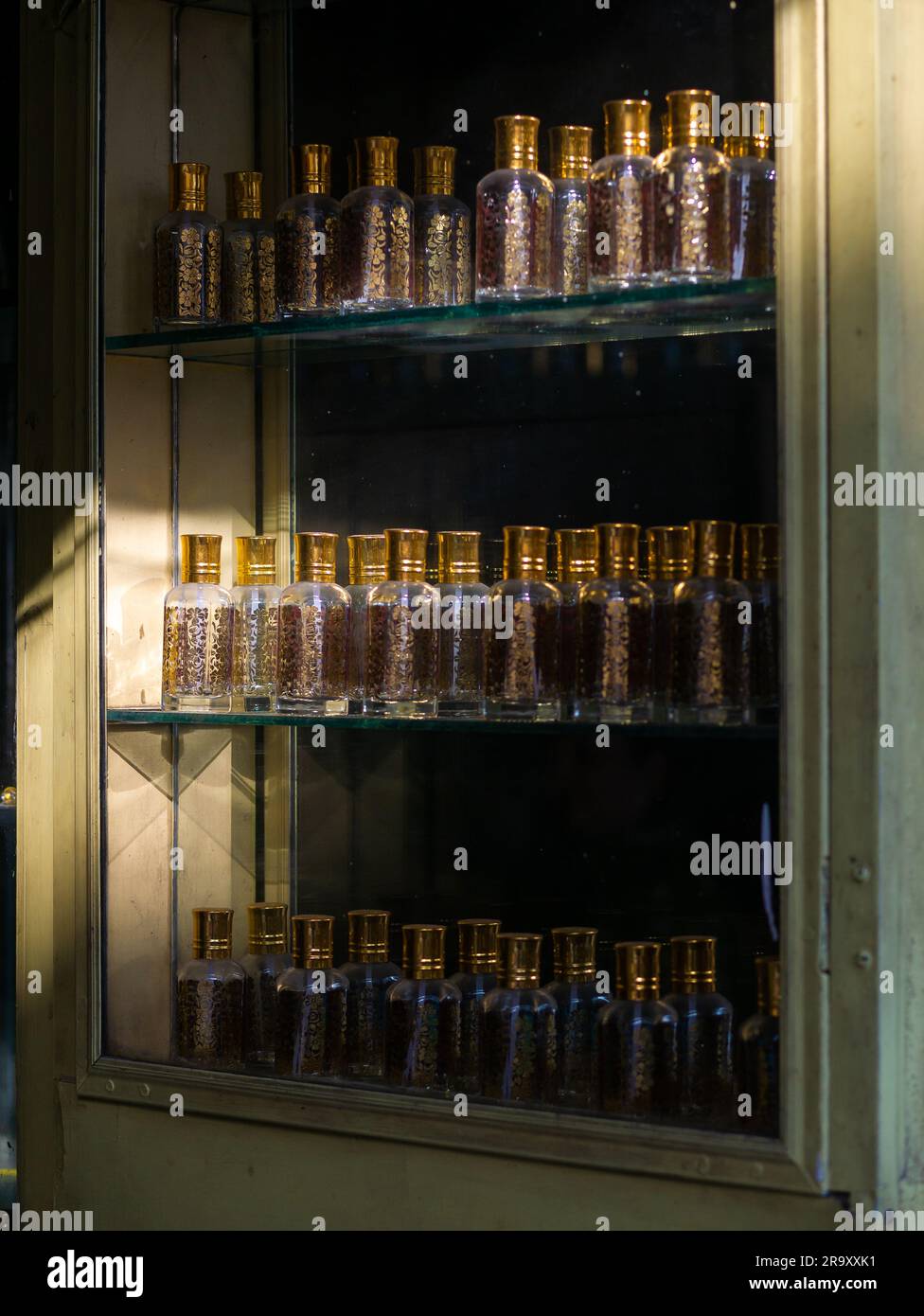 Großaufnahme von Attar- oder Parfümglasflaschen in einem Laden. Sonnenlicht auf ein paar Flaschen. Stockfoto