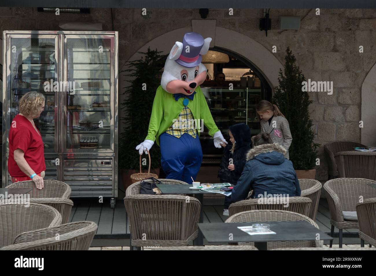 Kotor, Montenegro, 9. April 2023: Ein kostümierter Entertainer amüsiert Kinder in einem Café im Freien Stockfoto