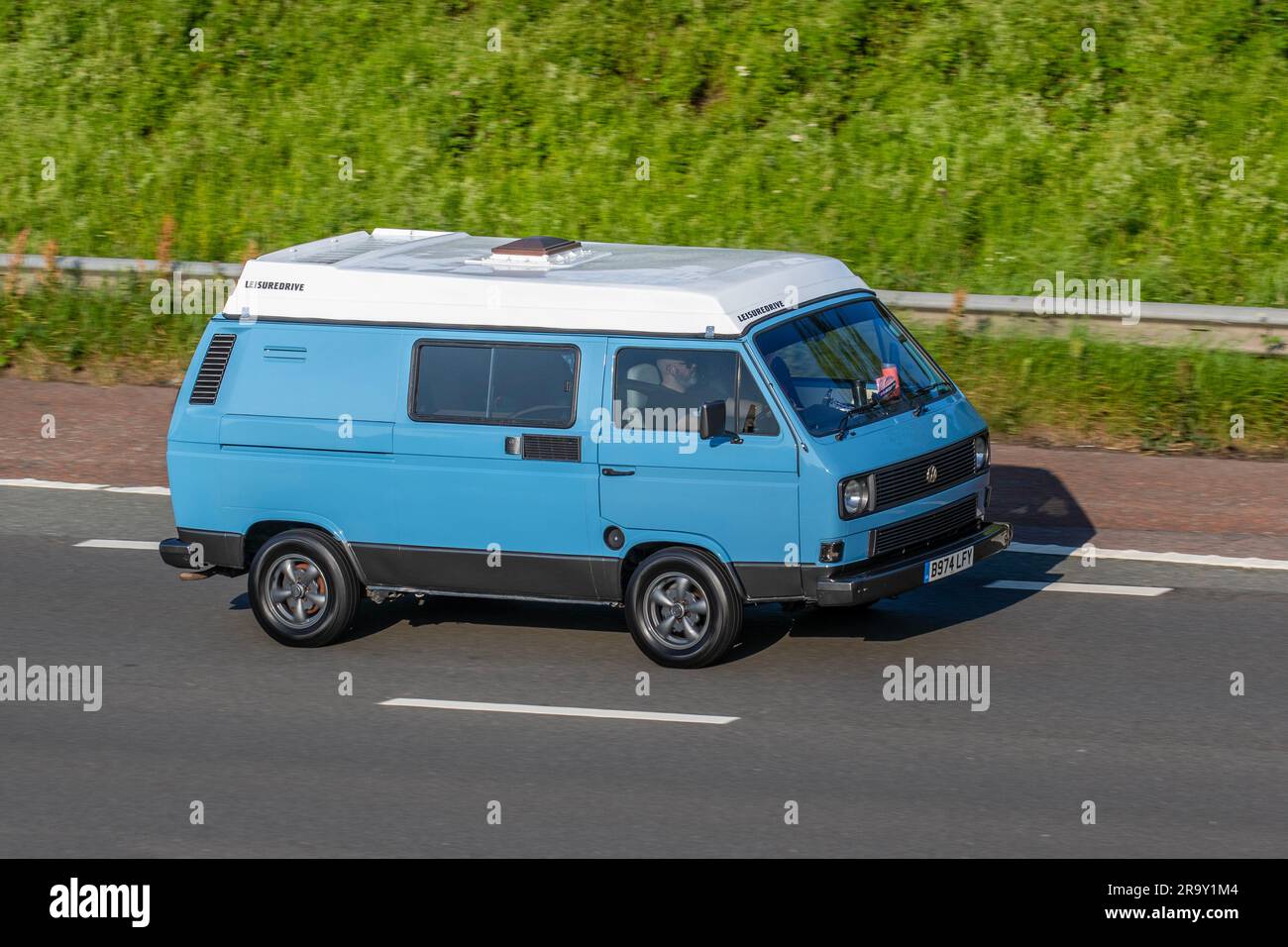 1985 50s Fifties Leisuretime Volkswagen Transporter 78Ps Blue LCV Minibus Benzinmotor 1915 cm3 mit hoher Geschwindigkeit auf der Autobahn M6 in Greater Manchester, Großbritannien Stockfoto
