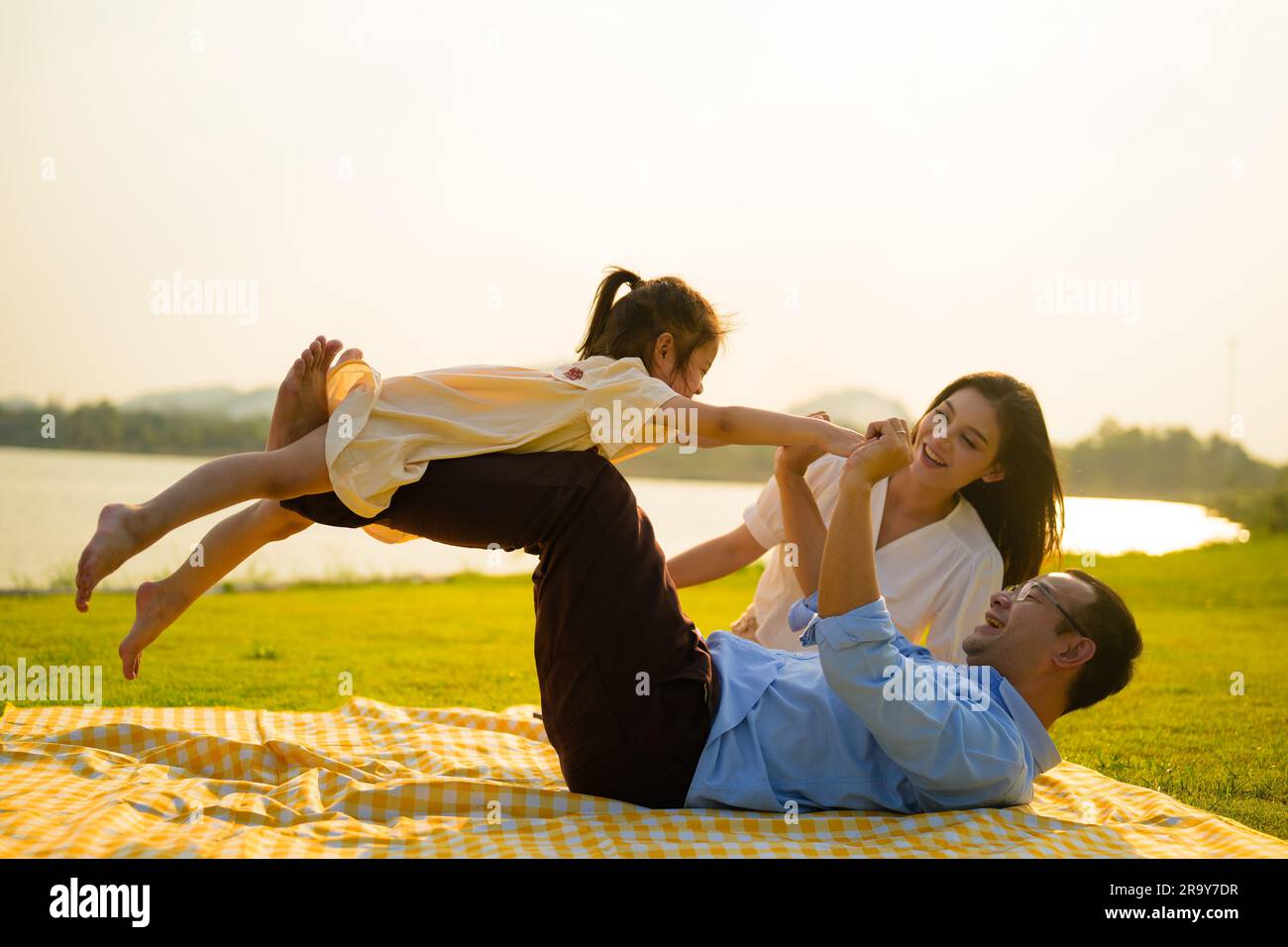 Lächelnde Eltern verbringen ihre Reisezeit mit Kindern im Park Stockfoto