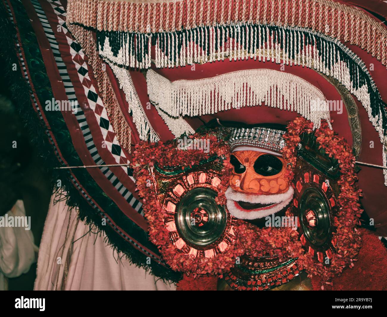 theyyam, eine beliebte Kunstform der Gottesdienste, die in kerala praktiziert wird, von einem Künstler in einem traditionellen Kostüm während des Tempelfestivals als Ritual aufgeführt Stockfoto