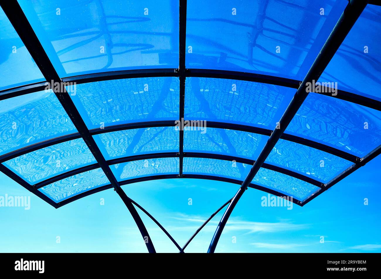 Transparentes, geschwungenes Vordach am blauen Himmel Stockfoto