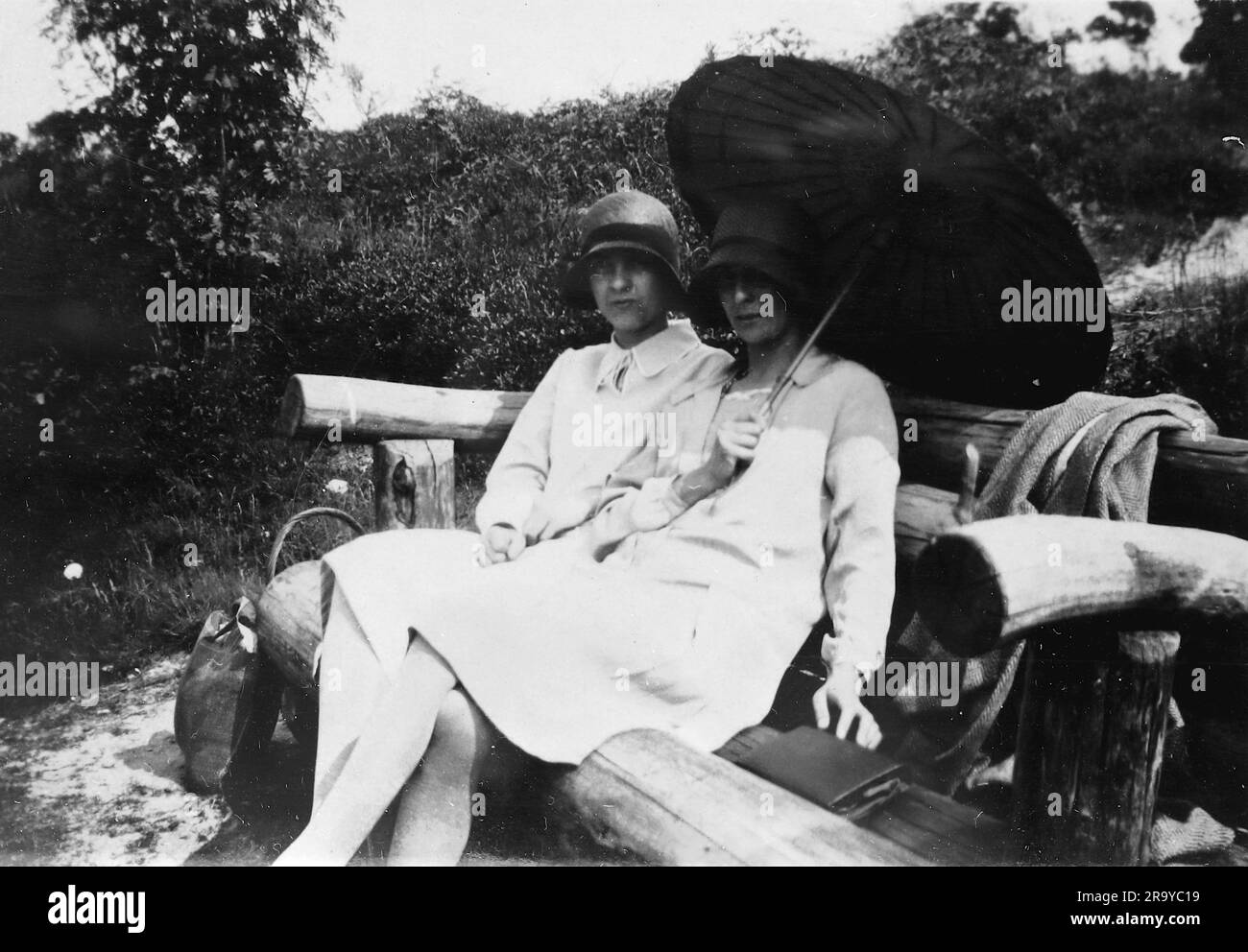 Zwei Damen, eine mit Sonnenschirm, sitzen auf dem Land von Surrey. Foto aus einem Familienalbum mit Bildern, die hauptsächlich im Vereinigten Königreich aufgenommen wurden, um 1929. Die Familie lebte in Witley, Surrey, und hatte Verbindungen zum Militär. Stockfoto
