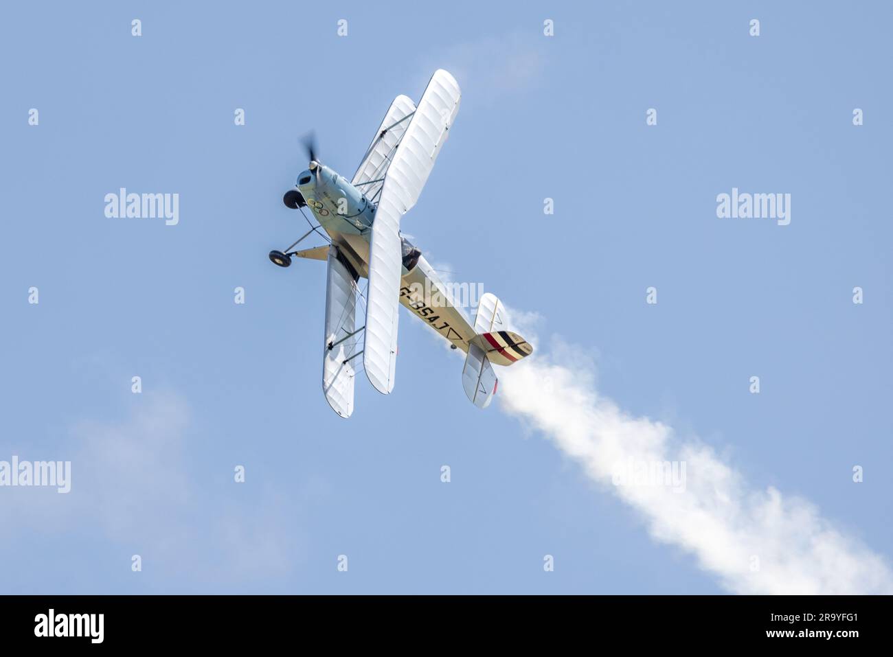 Bücher Jungmann G-BSAJ mit dem Farbschema der Olympischen Spiele 1936, in der Luft auf der Around the World Airshow am 4. Juni 2023 in Shuttleworth. Stockfoto