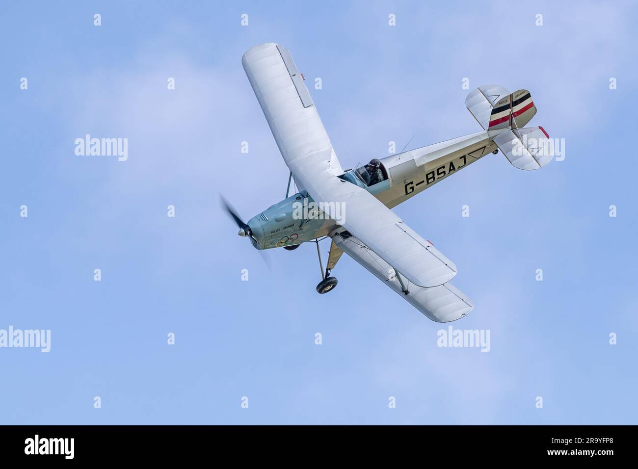 Bücher Jungmann G-BSAJ mit dem Farbschema der Olympischen Spiele 1936, in der Luft auf der Around the World Airshow am 4. Juni 2023 in Shuttleworth. Stockfoto