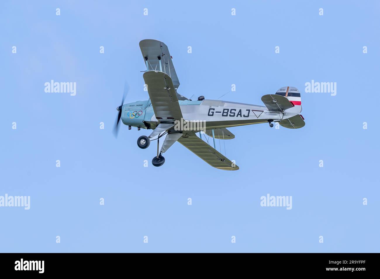 Bücher Jungmann G-BSAJ mit dem Farbschema der Olympischen Spiele 1936, in der Luft auf der Around the World Airshow am 4. Juni 2023 in Shuttleworth. Stockfoto