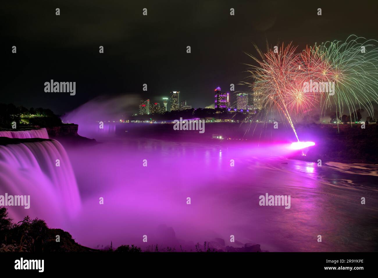 Die Niagarafälle in NY, USA, werden bei Nacht von einem farbenfrohen Feuerwerk beleuchtet Stockfoto